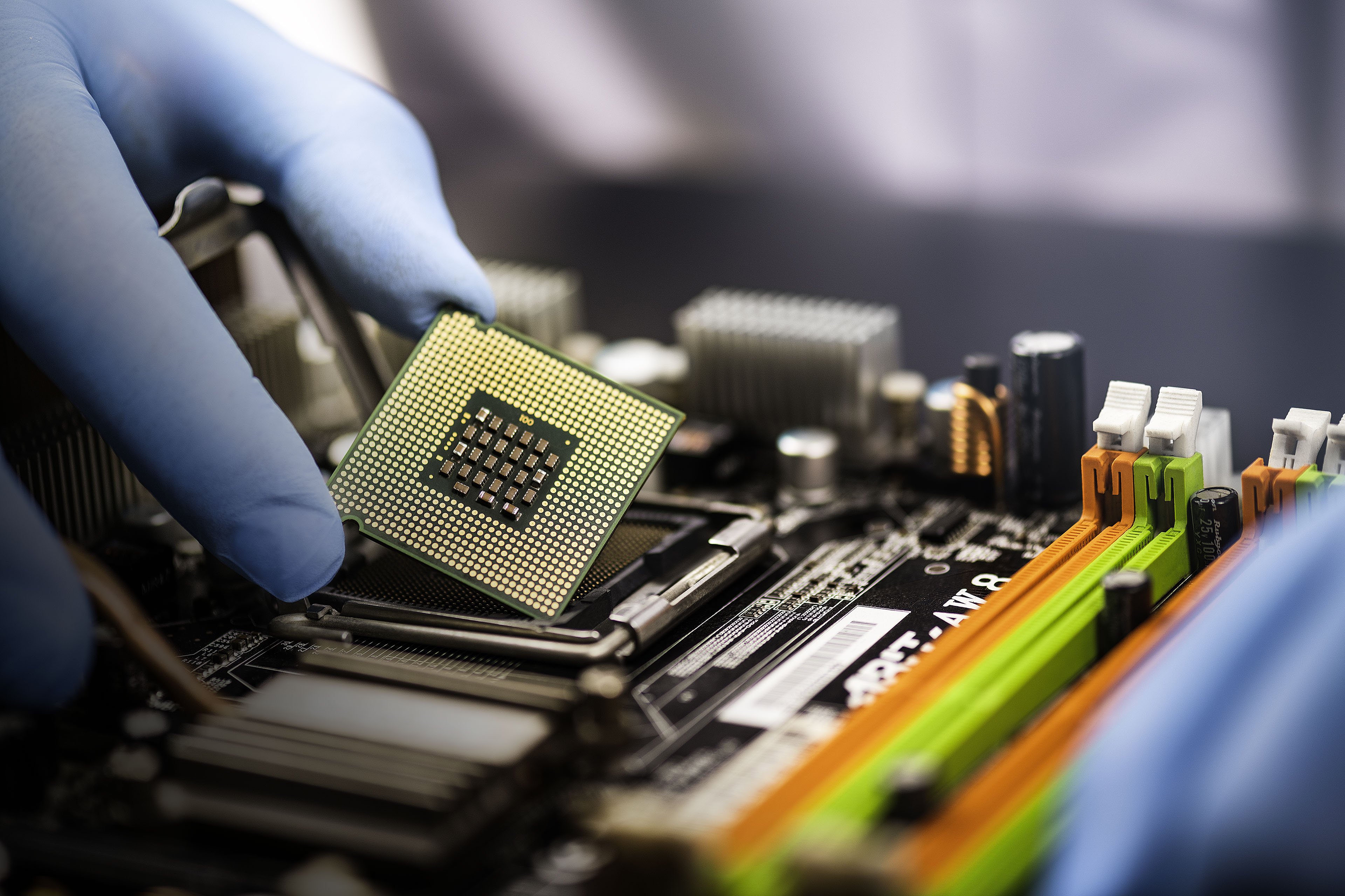 Engineer placing chip into motherboard on computer