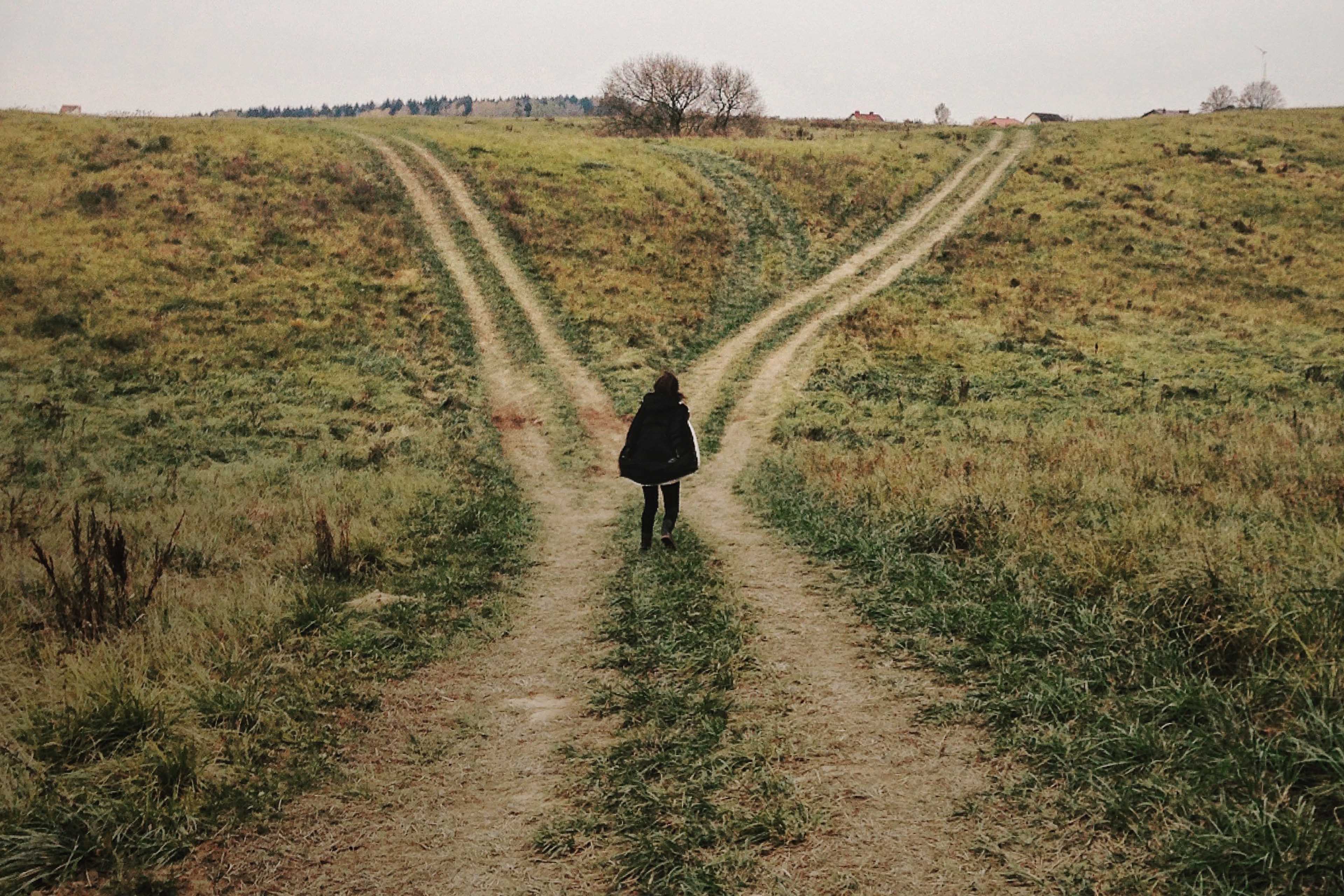 woman standing crossroads field v1