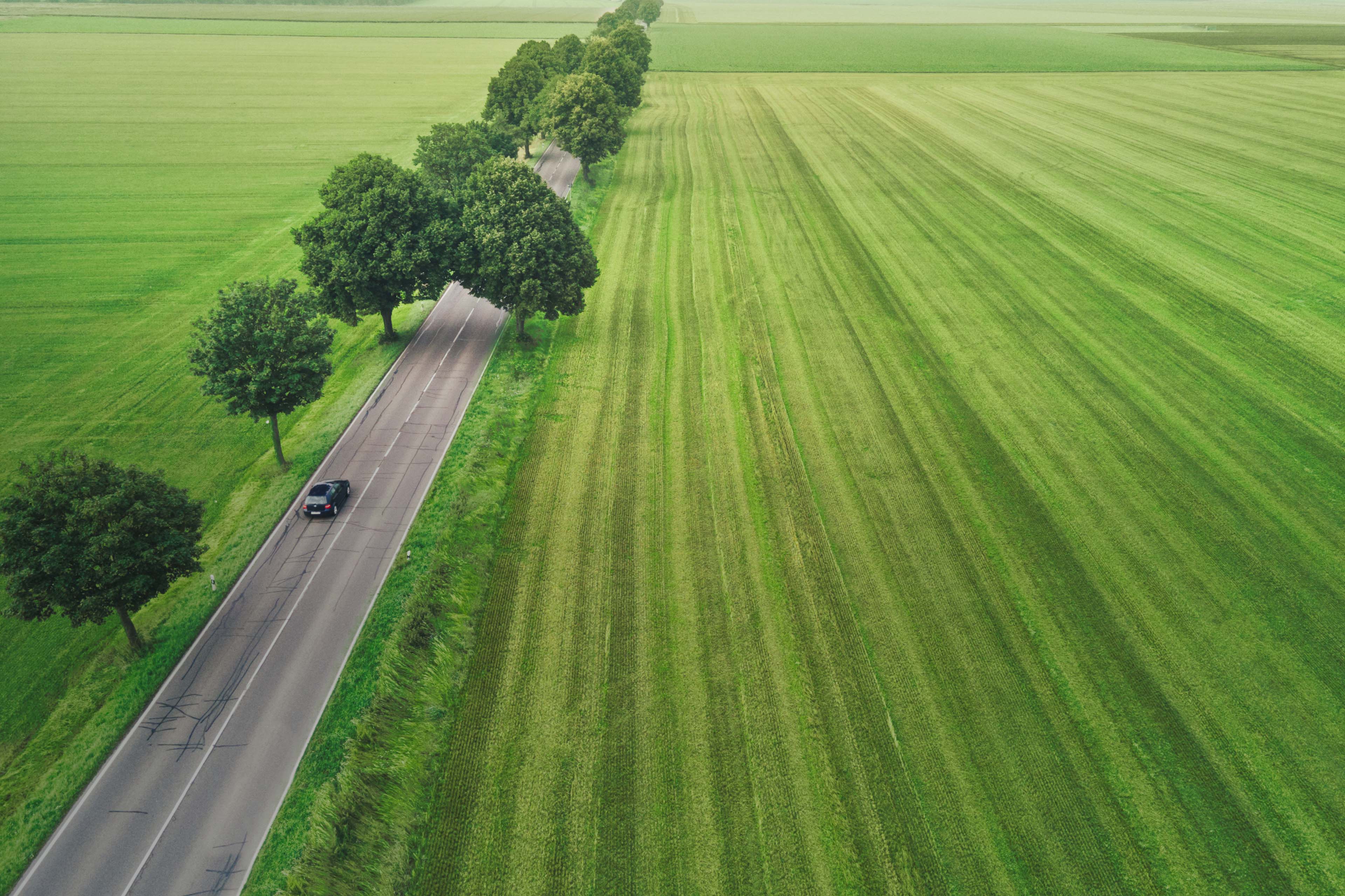 Aerial view of an electric vehicle in a green landscape