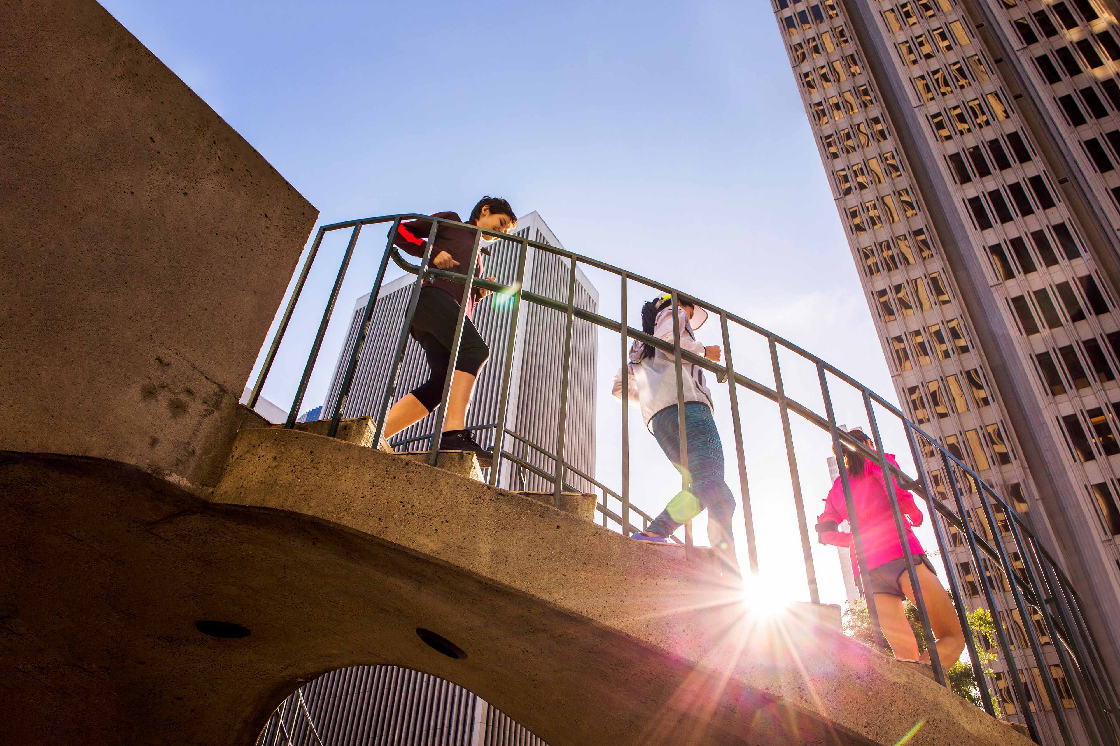 Low angle view of women running on urban staircase