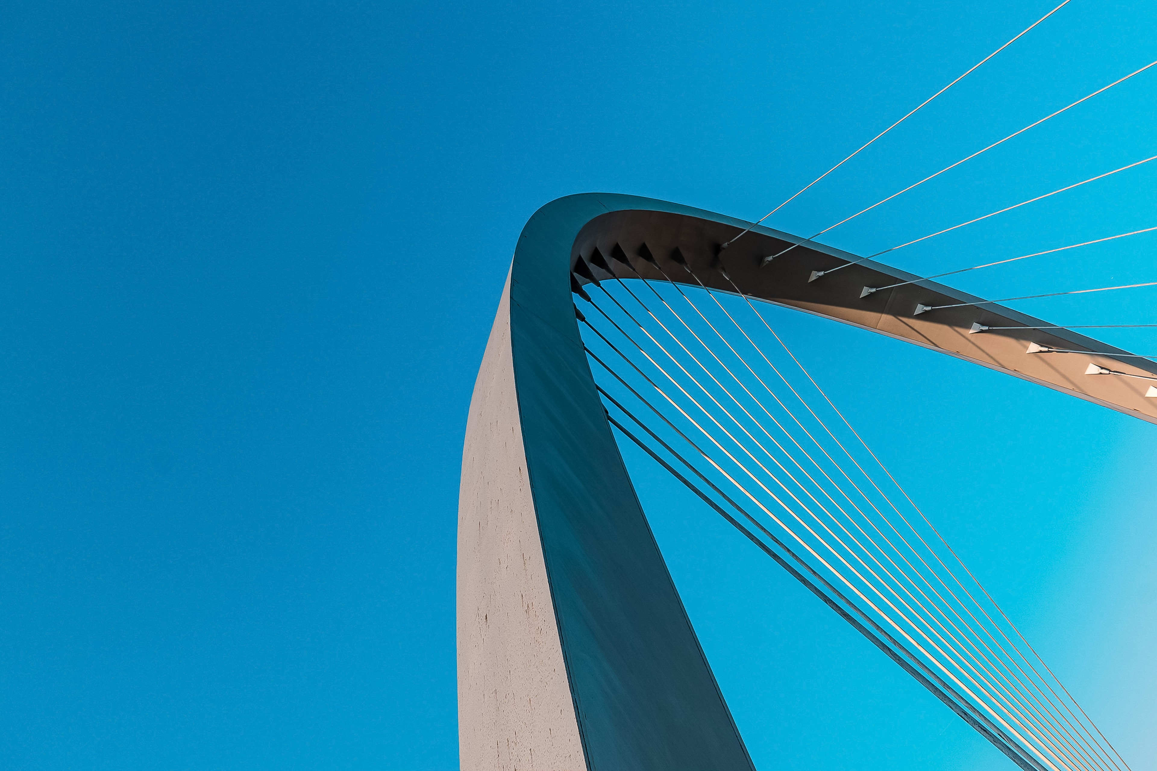 Low angle view of bridge arch against blue sky