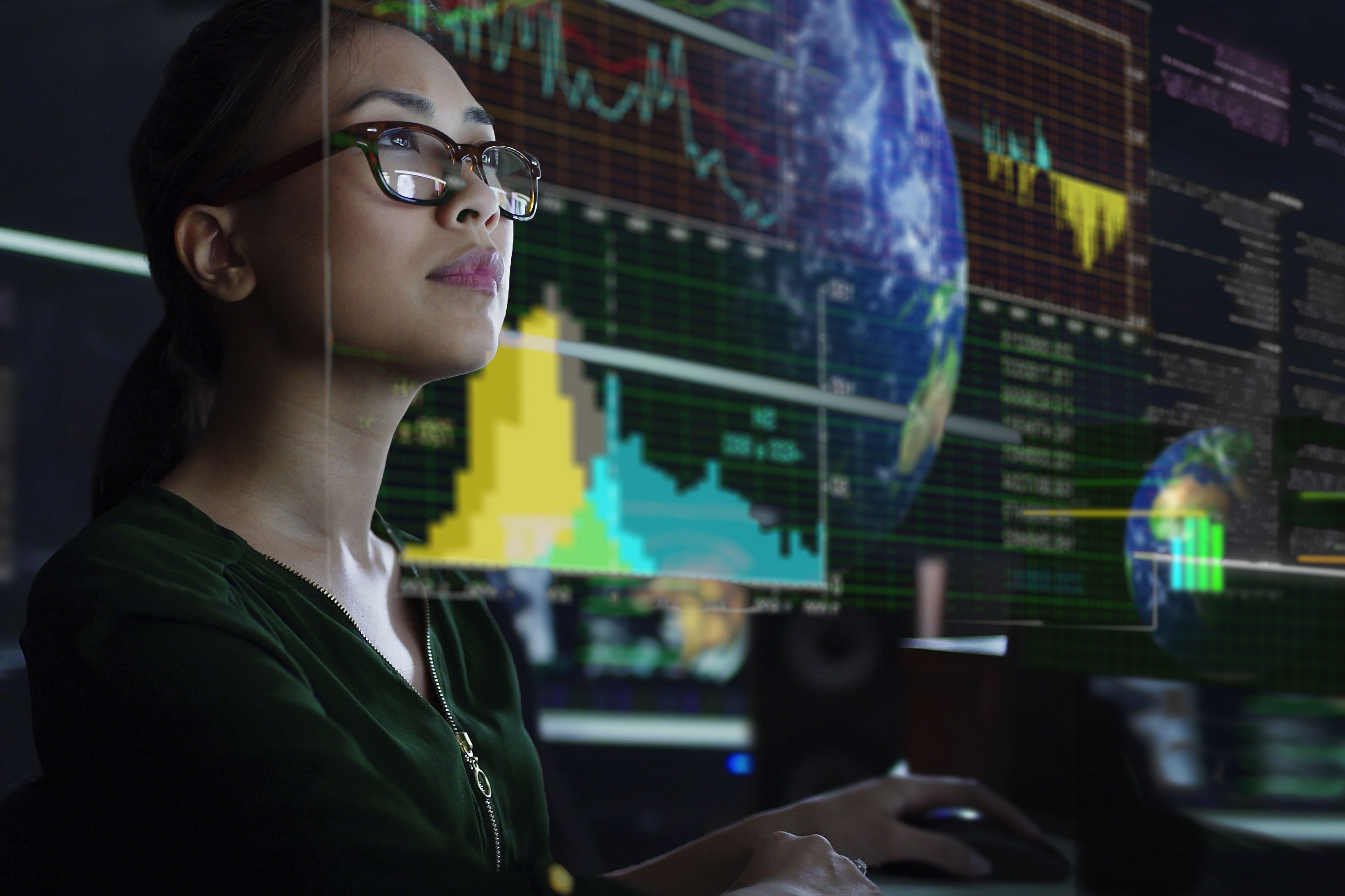 Woman looking at see through screen showing global environmental data