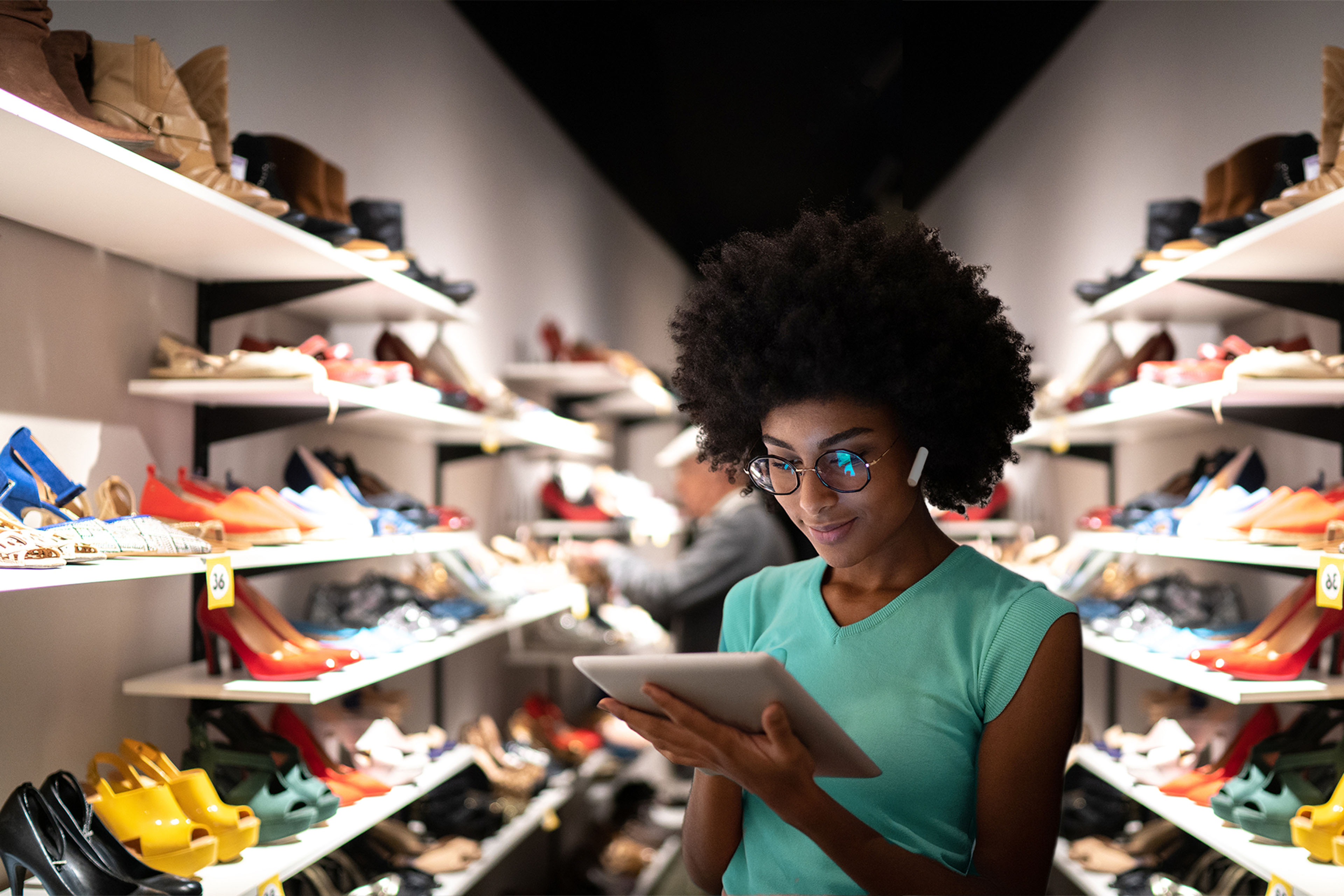 Young woman using digital tablet to check inventory at a shoe store