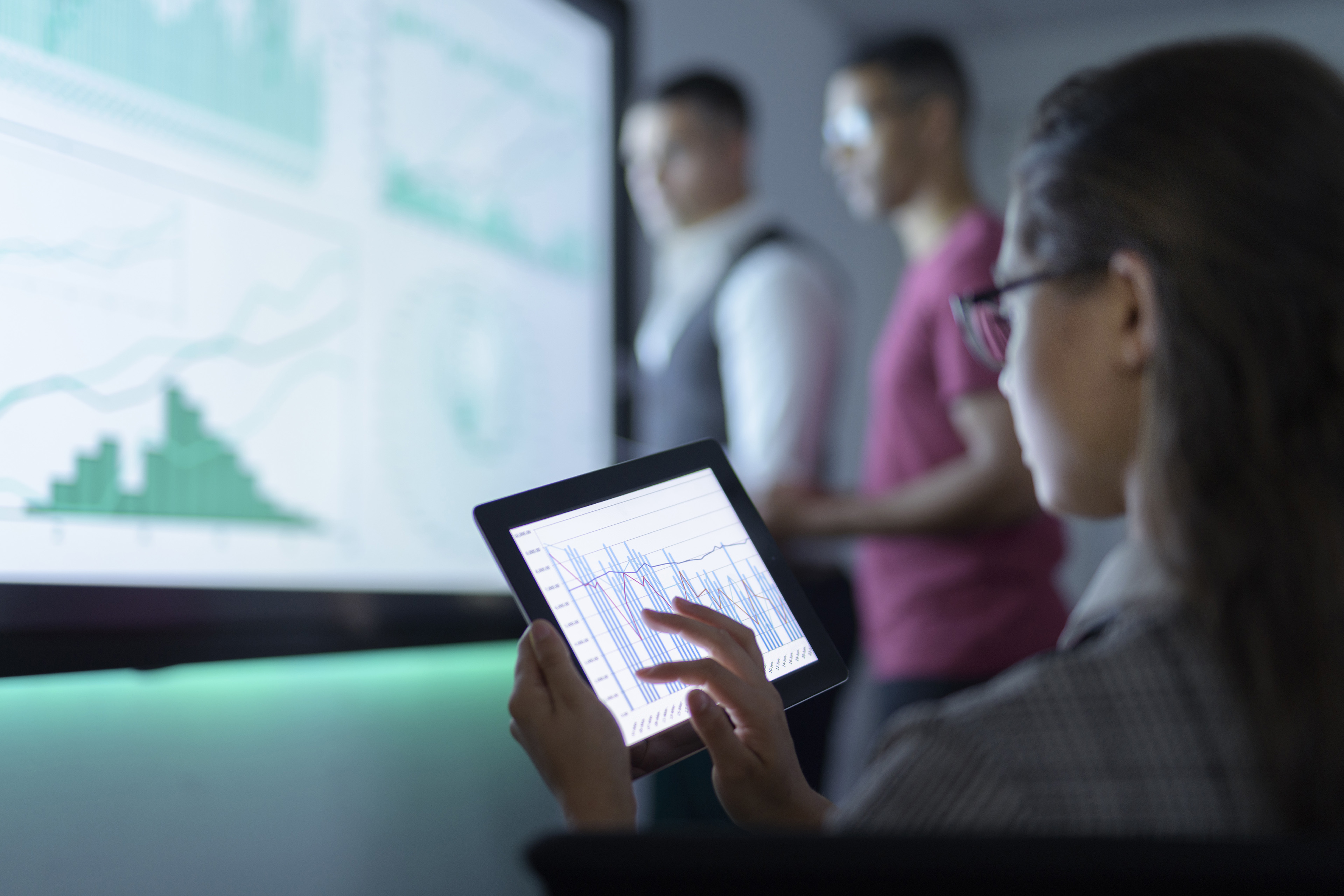 Businesswoman viewing graphs on digital tablet in business meeting