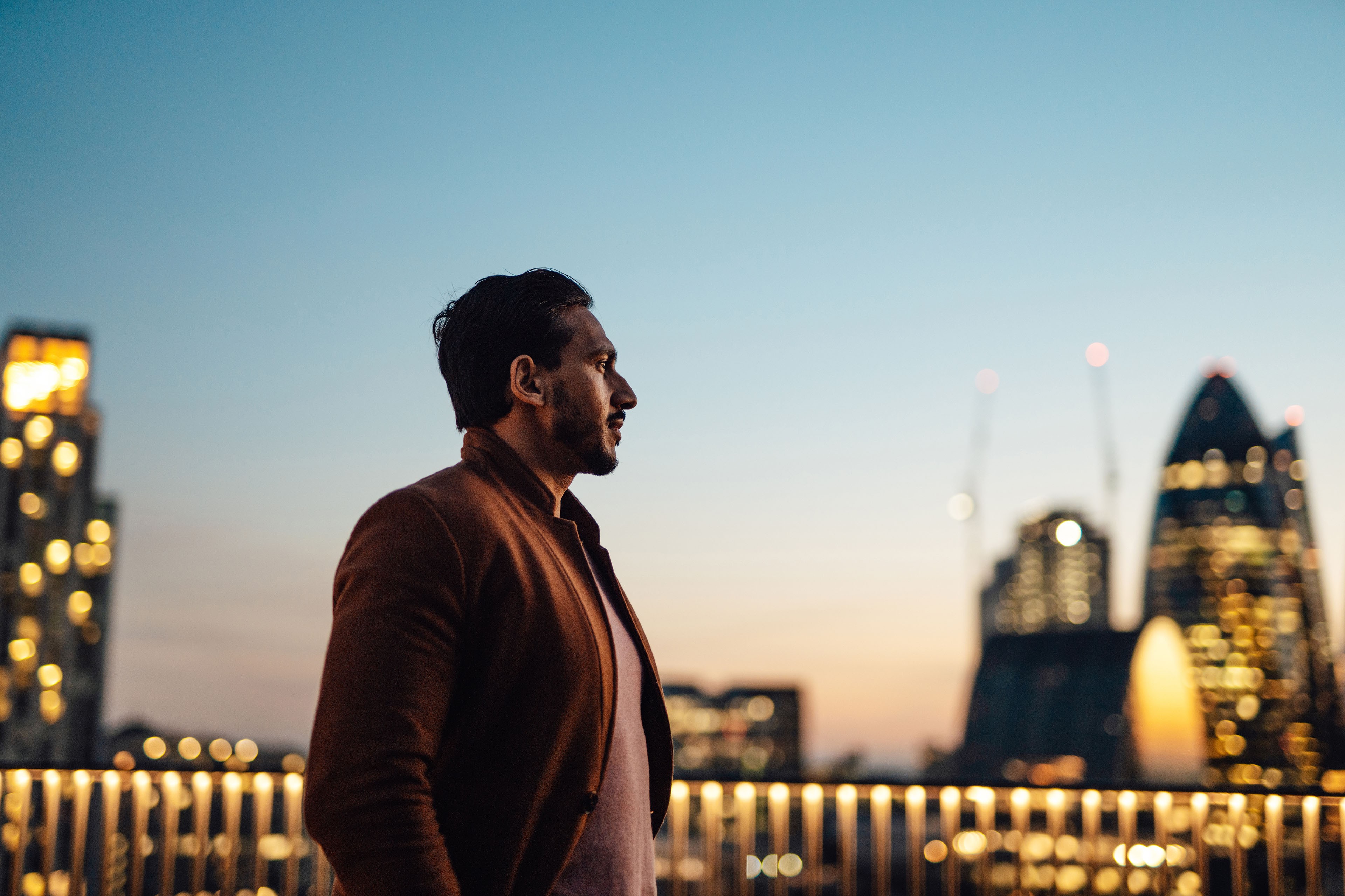 Businessman looking over city at rooftop in high rise business building