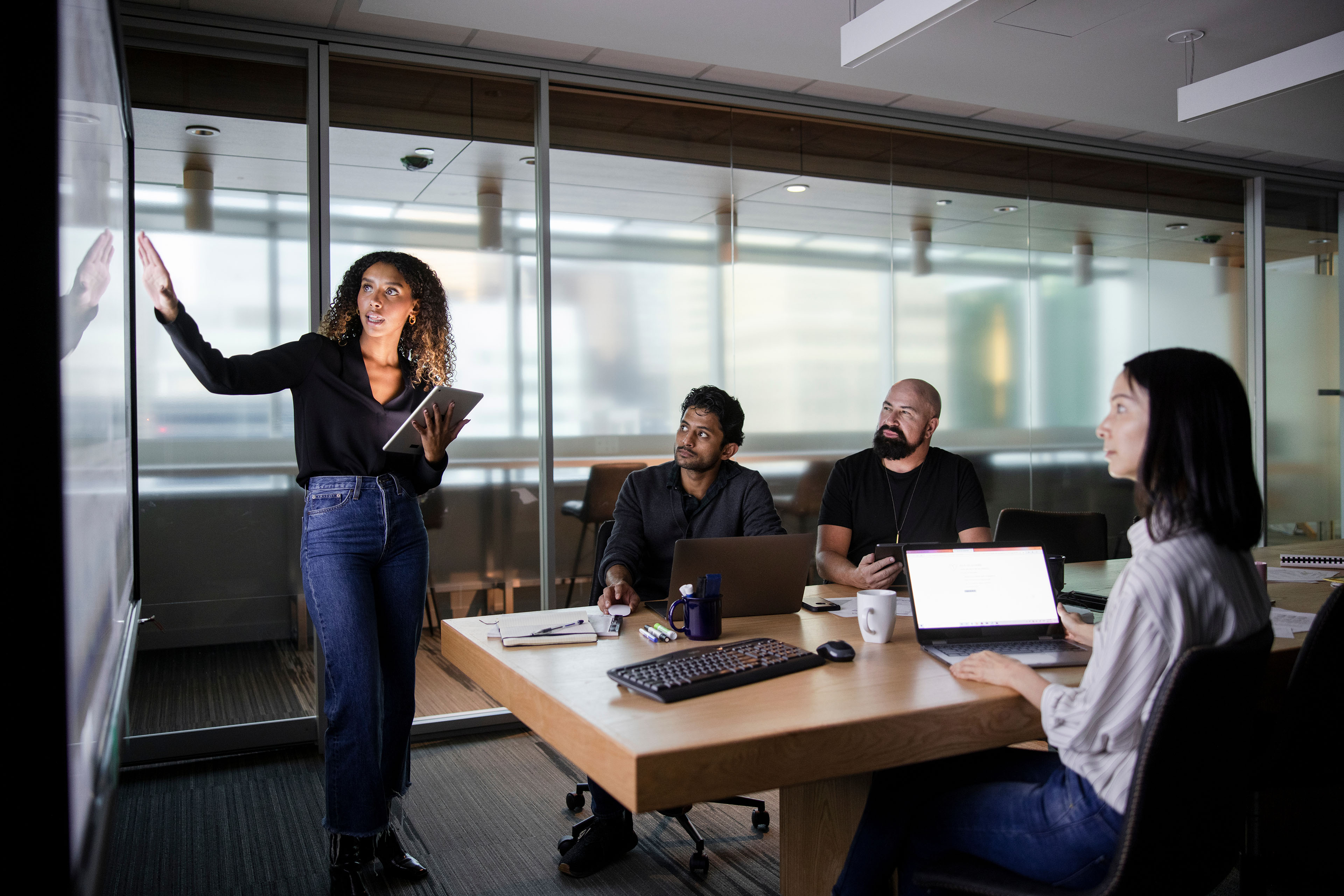 Businesswoman at projection screen leading conference room meeting