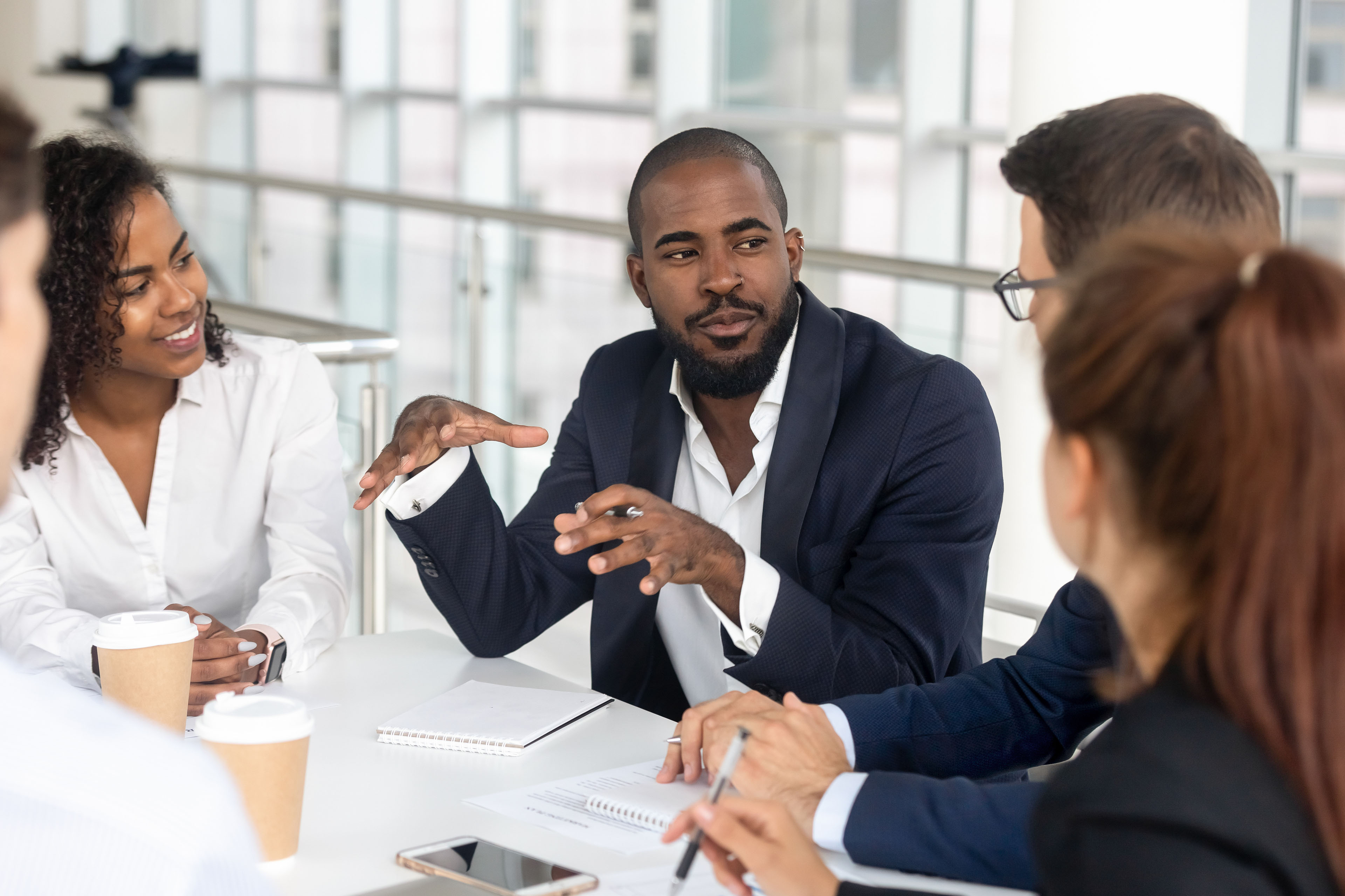 Manager leading corporate team during briefing in boardroom