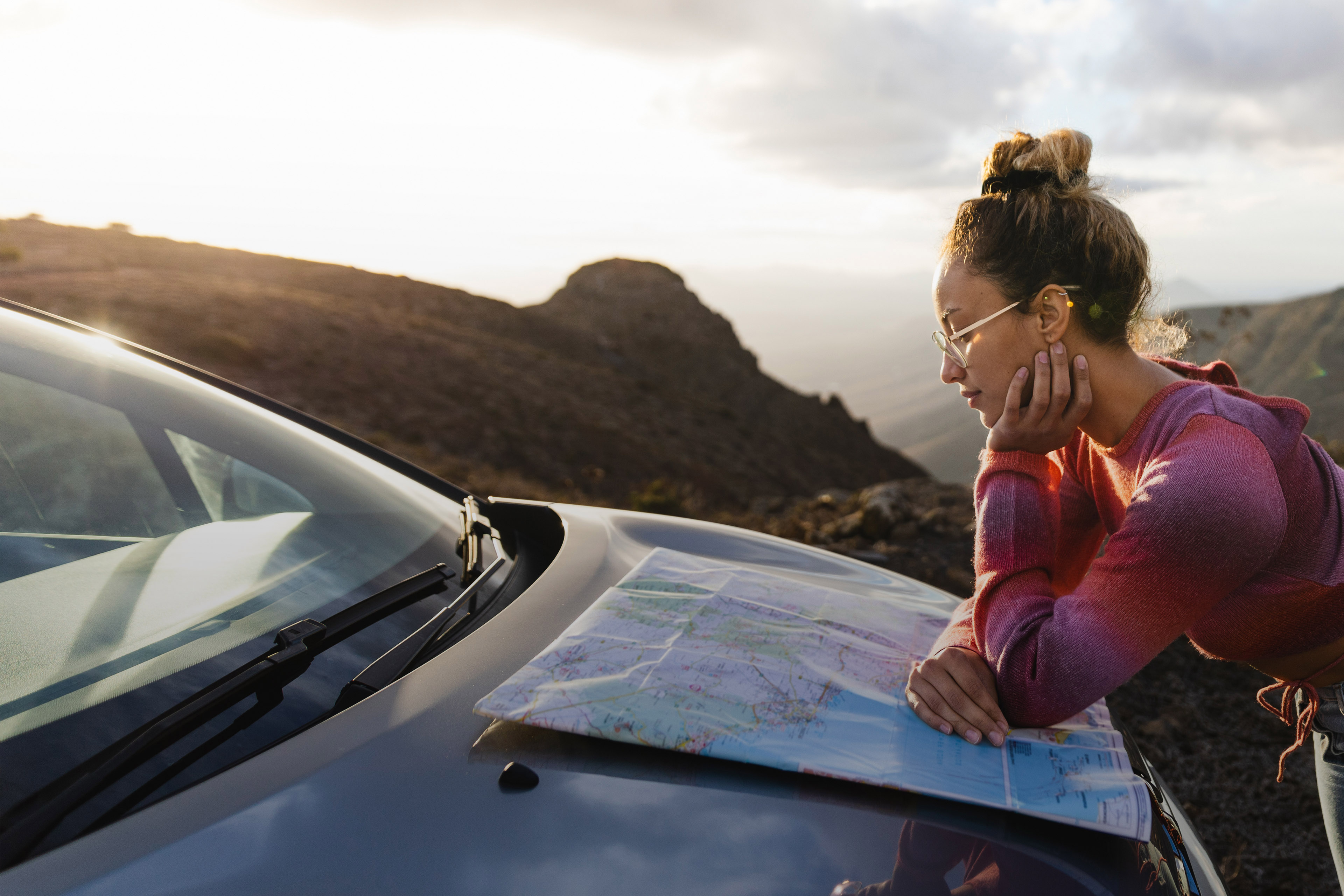 Side view of women looking at the map on her car