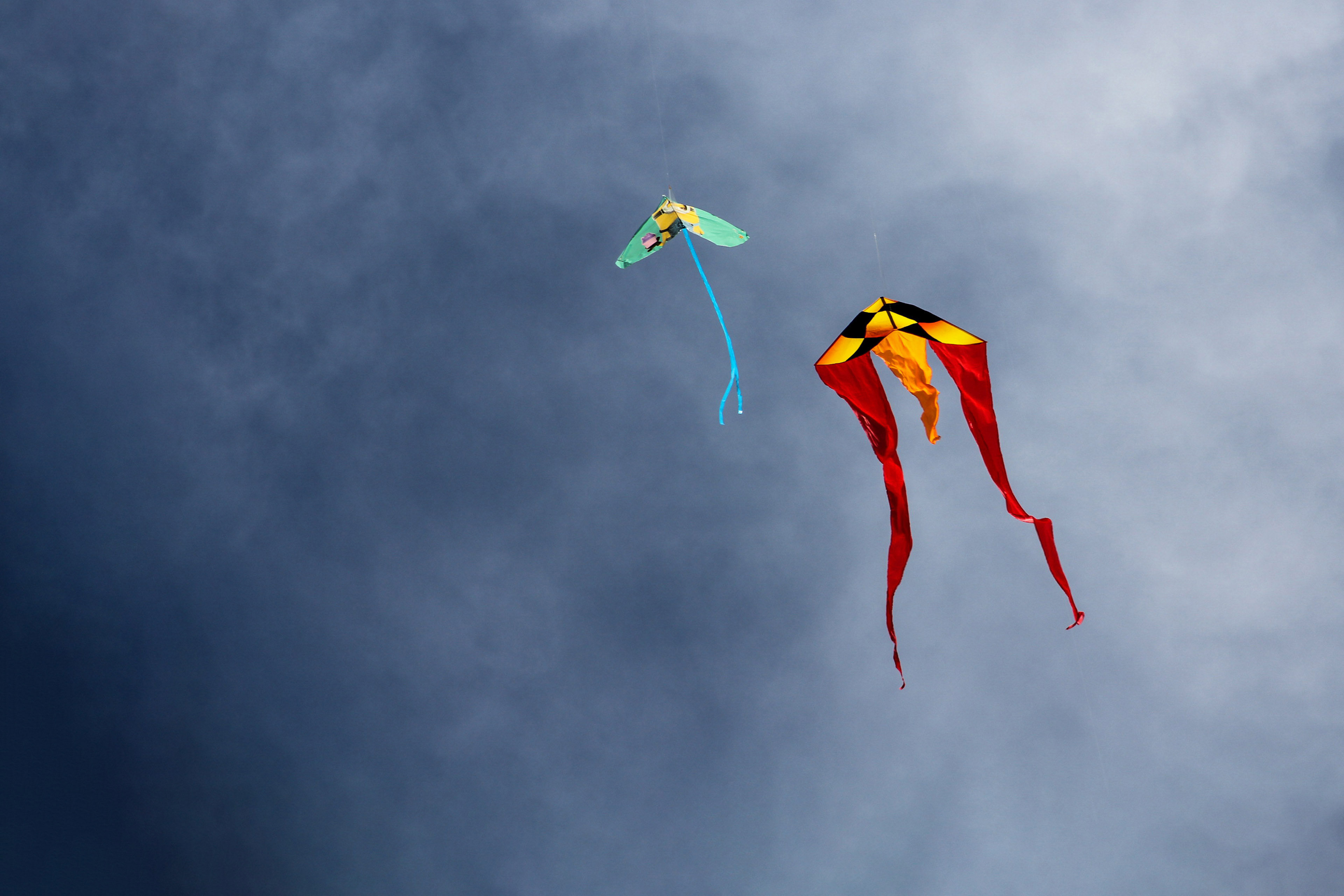 Low angle view of kites flying in sky