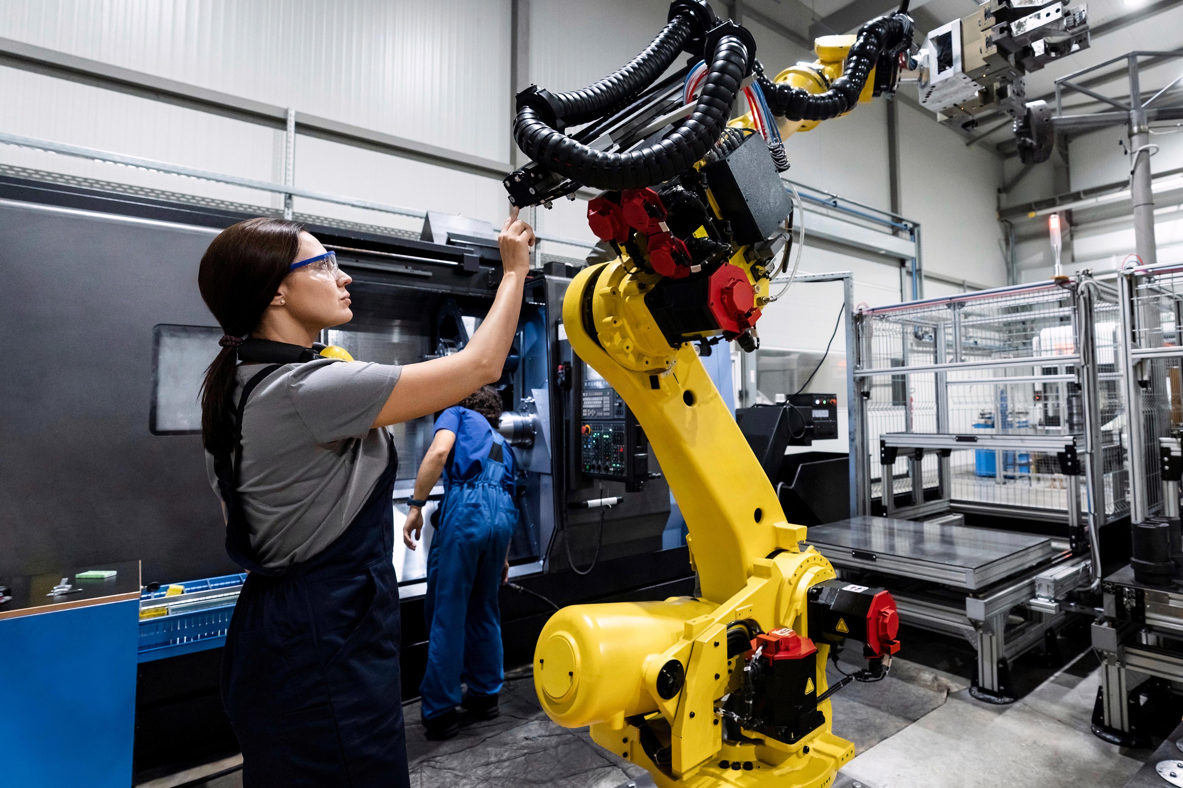 Female worker repairing a machine in industrial premises