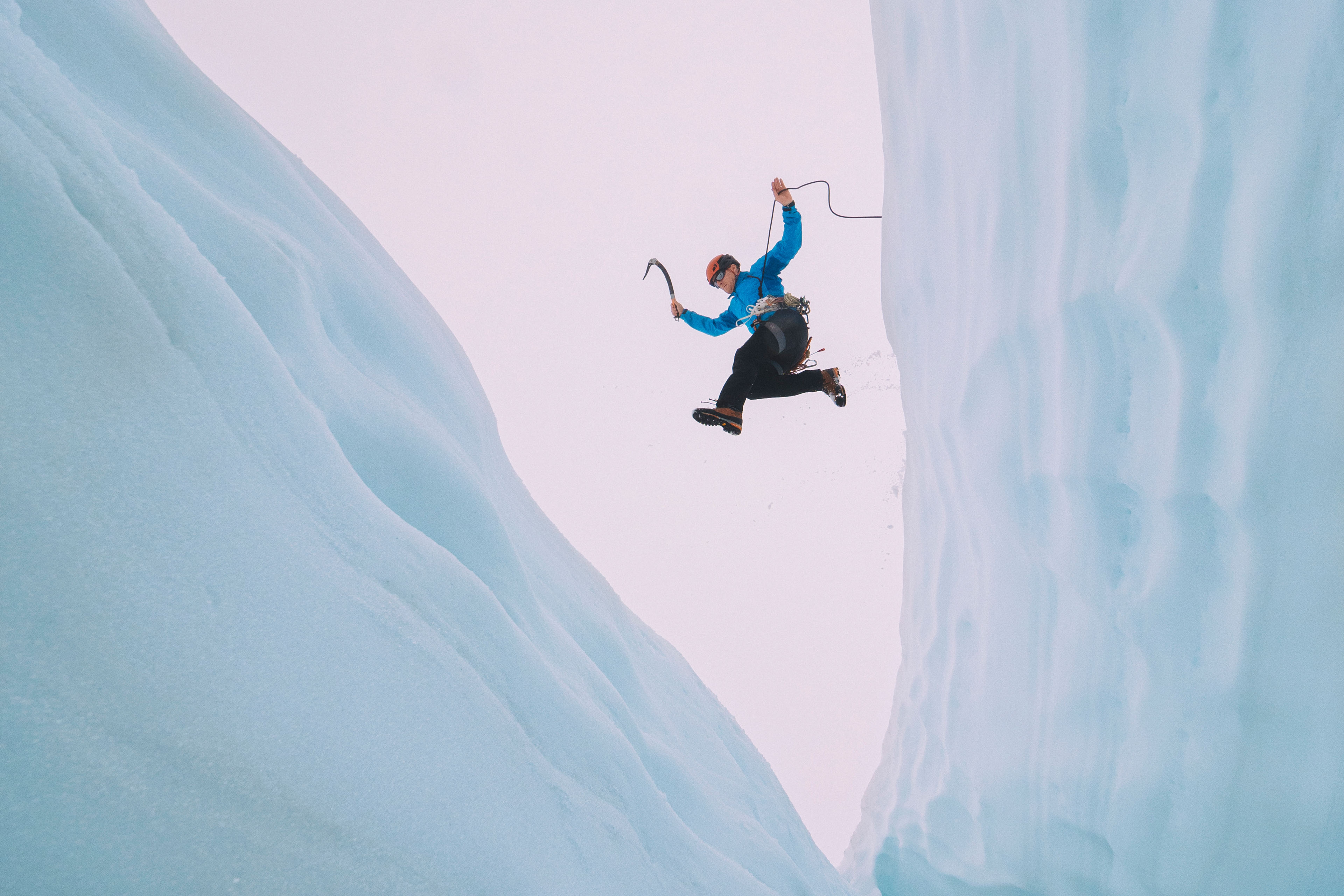 Mountaineer jumps over large crevasse