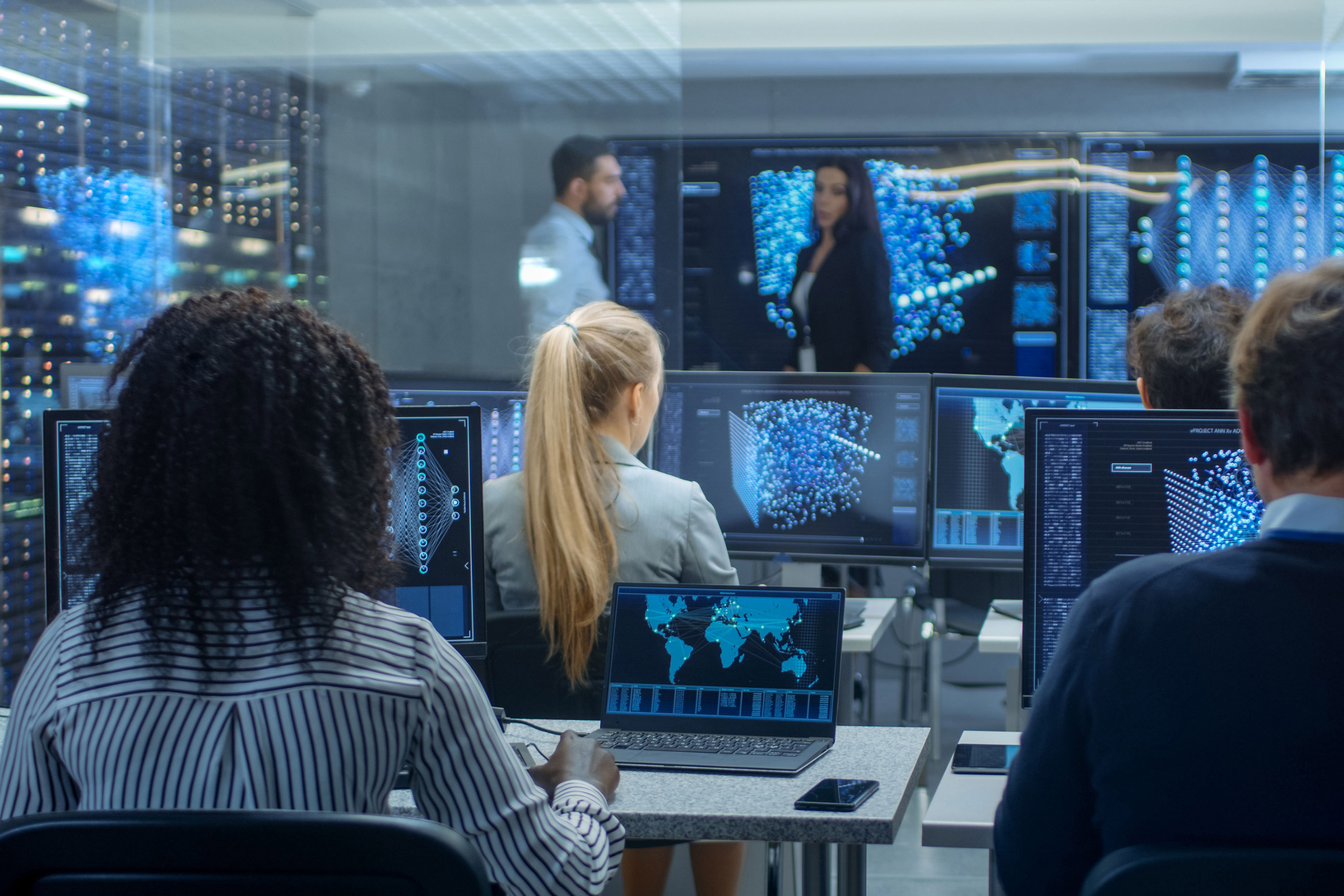 Employees discussing about data by sitting infront of systems