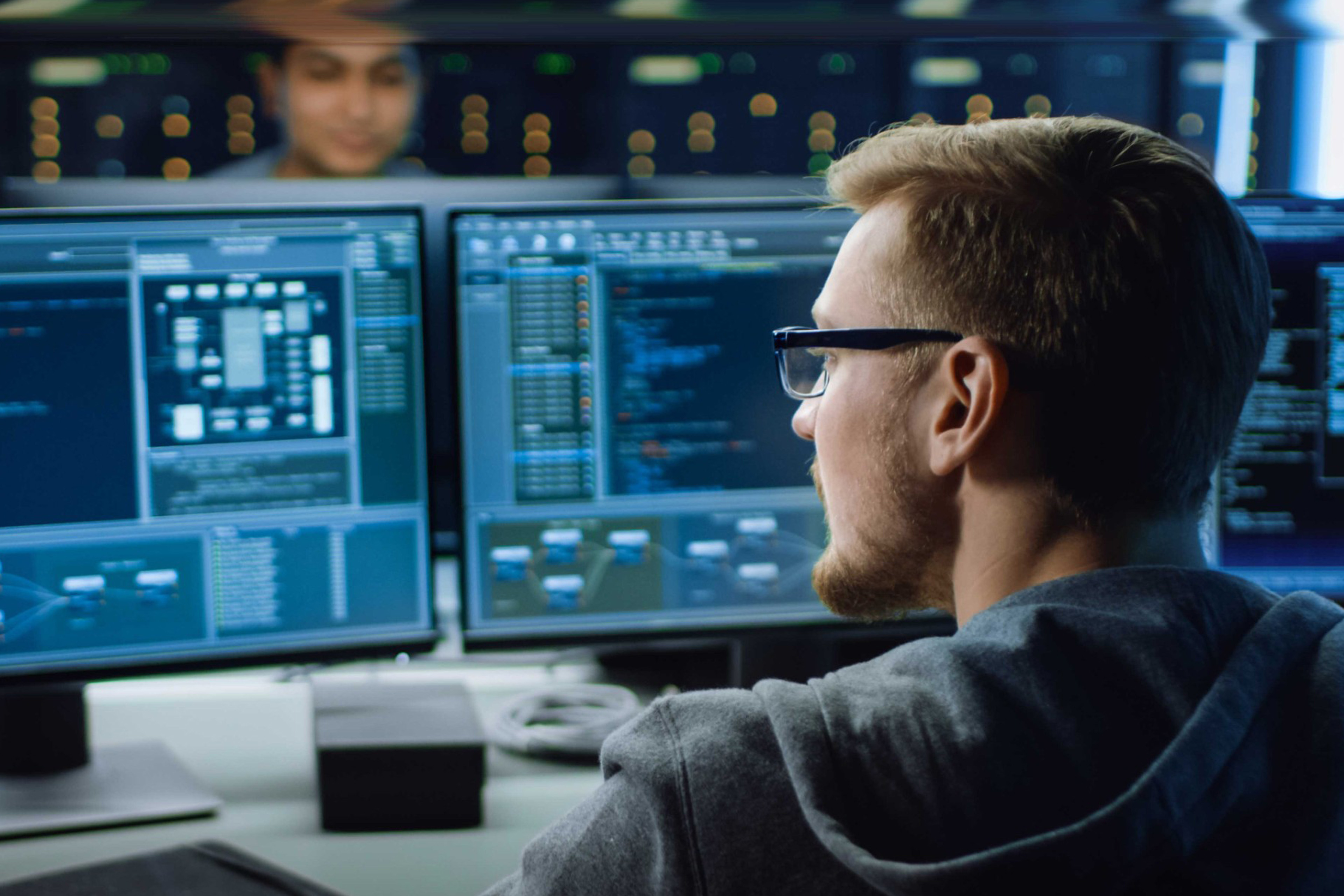 Man observing the data by comparing two monitors