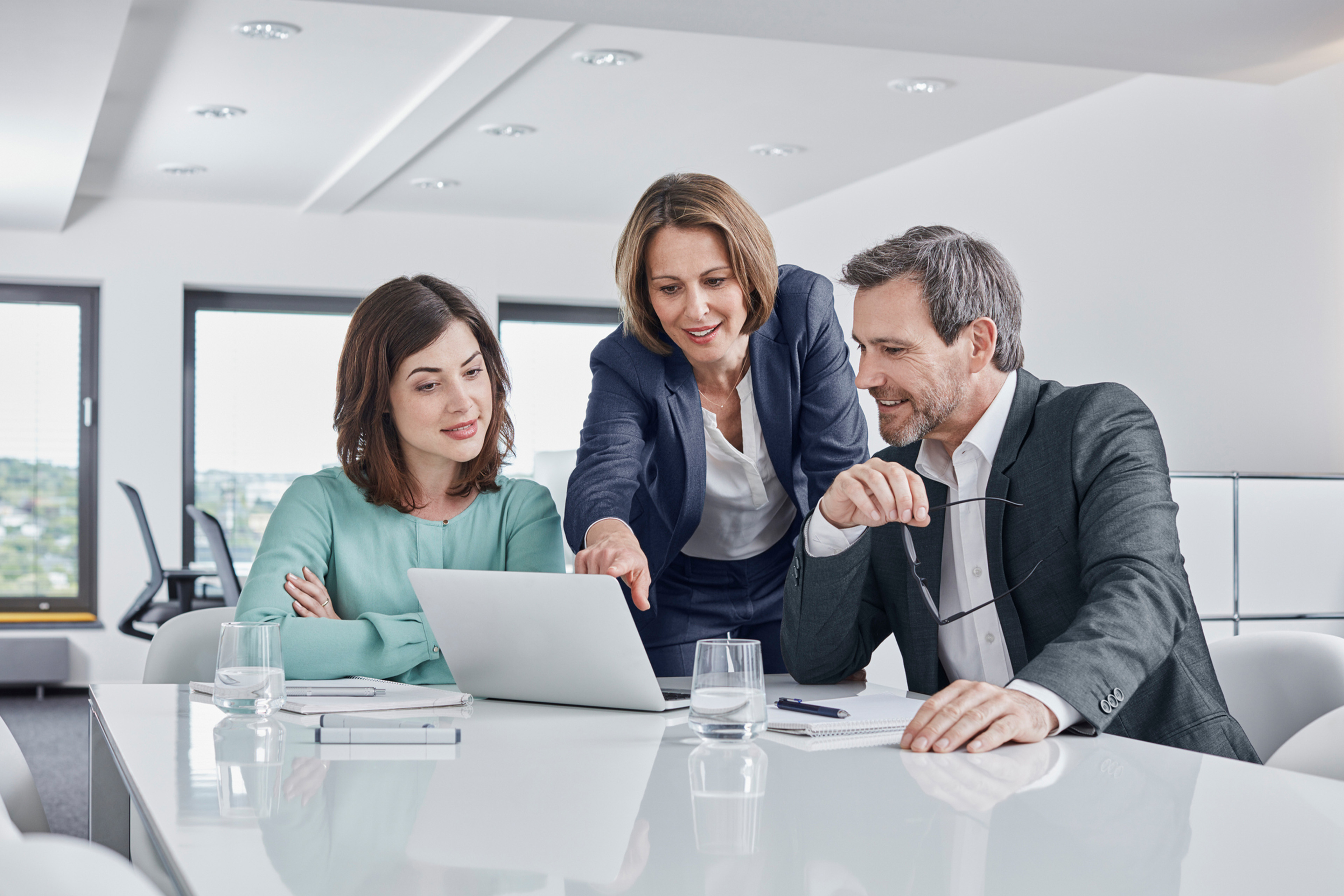 Three members discussing about work in Laptop