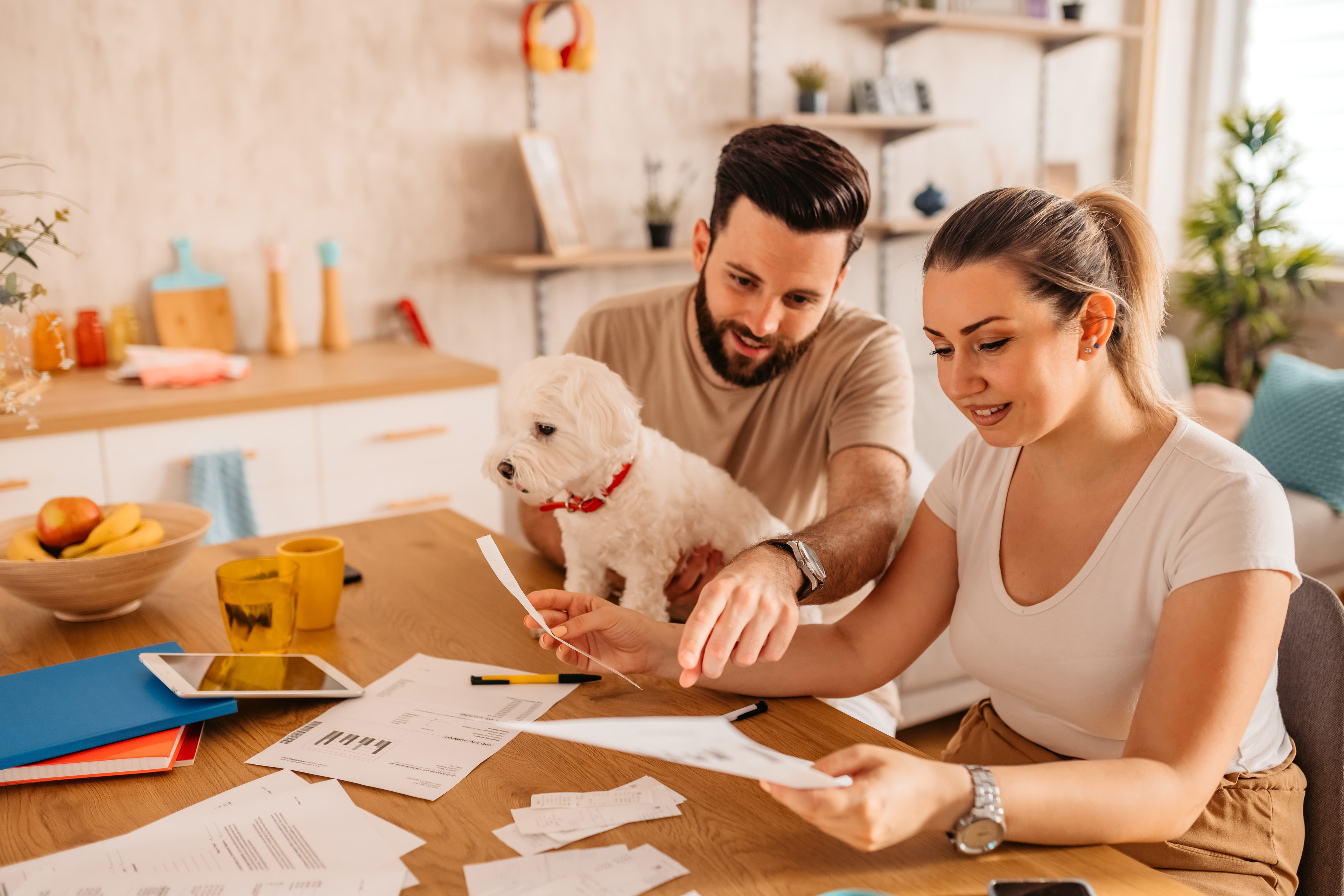 Young couple sitting in their living room and checking their finances.