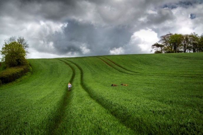 EY rain clouds threaten a child walking through field