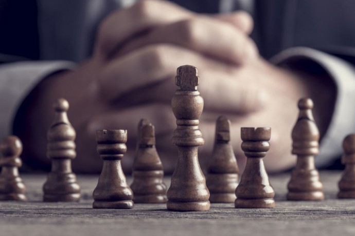 A person sitting in front of chess board