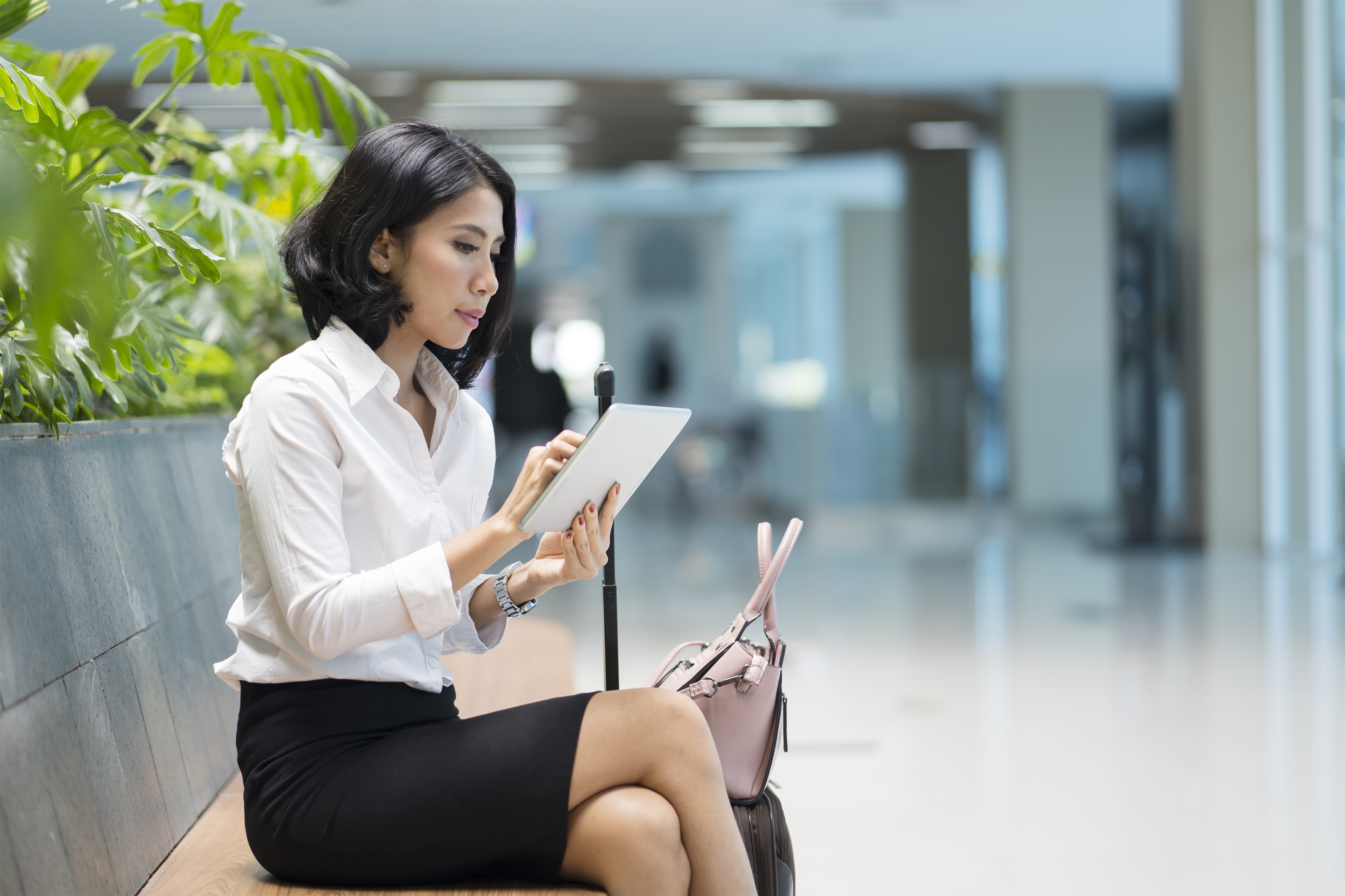 A woman in formal clothes using ipad