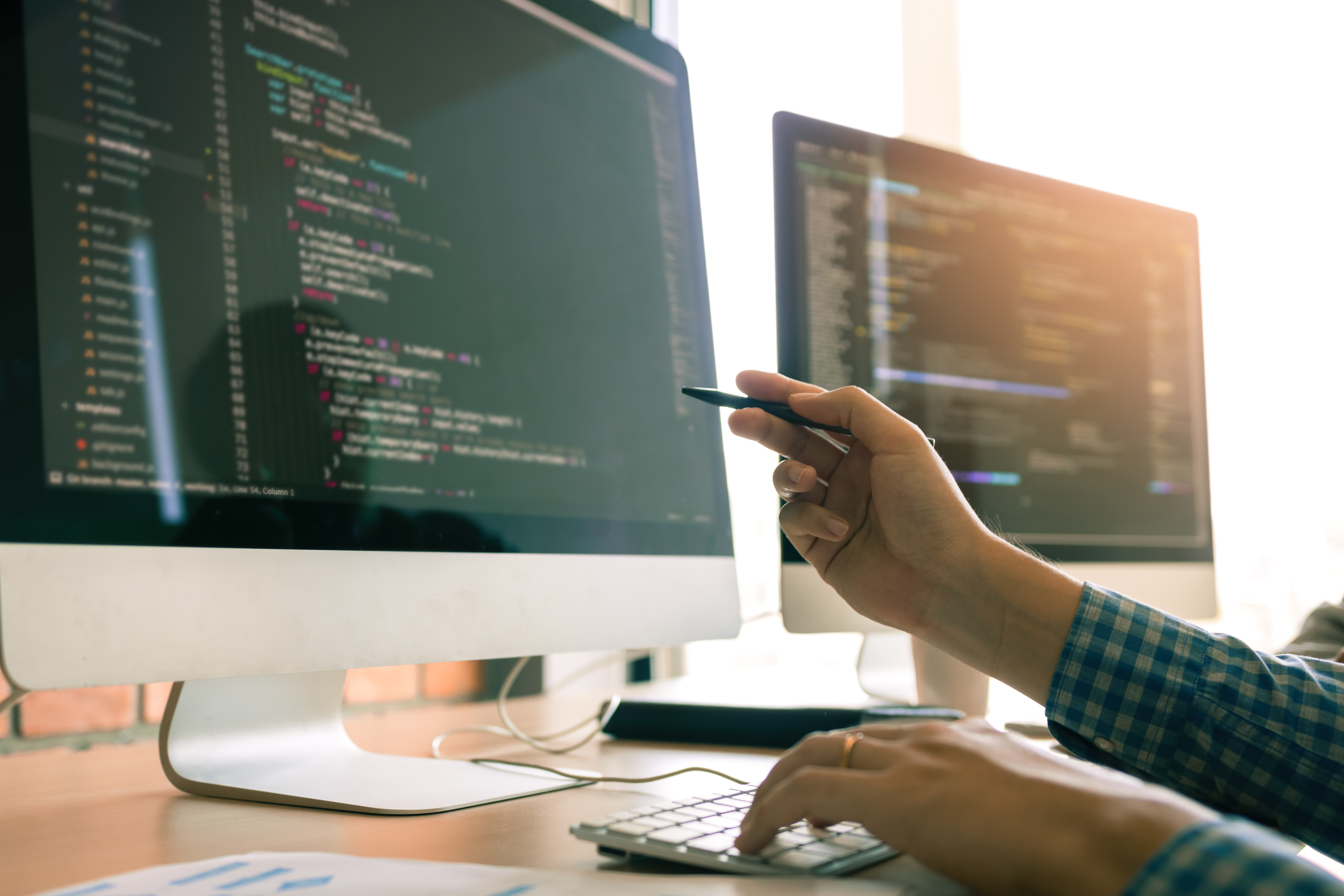 Developing programming working in a software engineers code tech applications on desk in office room.