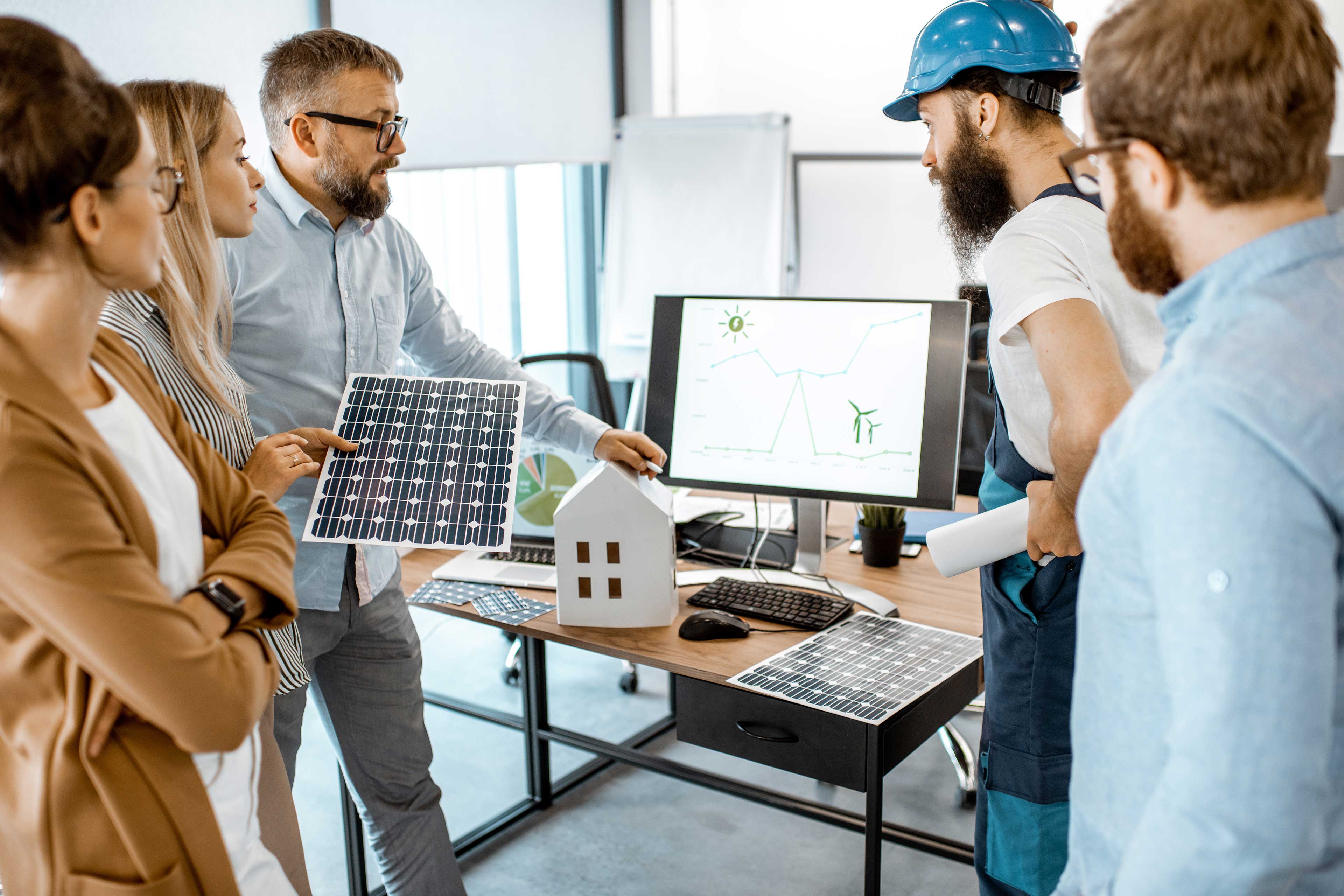 Alternative energy engineers discussing a project with a worker during an office meeting