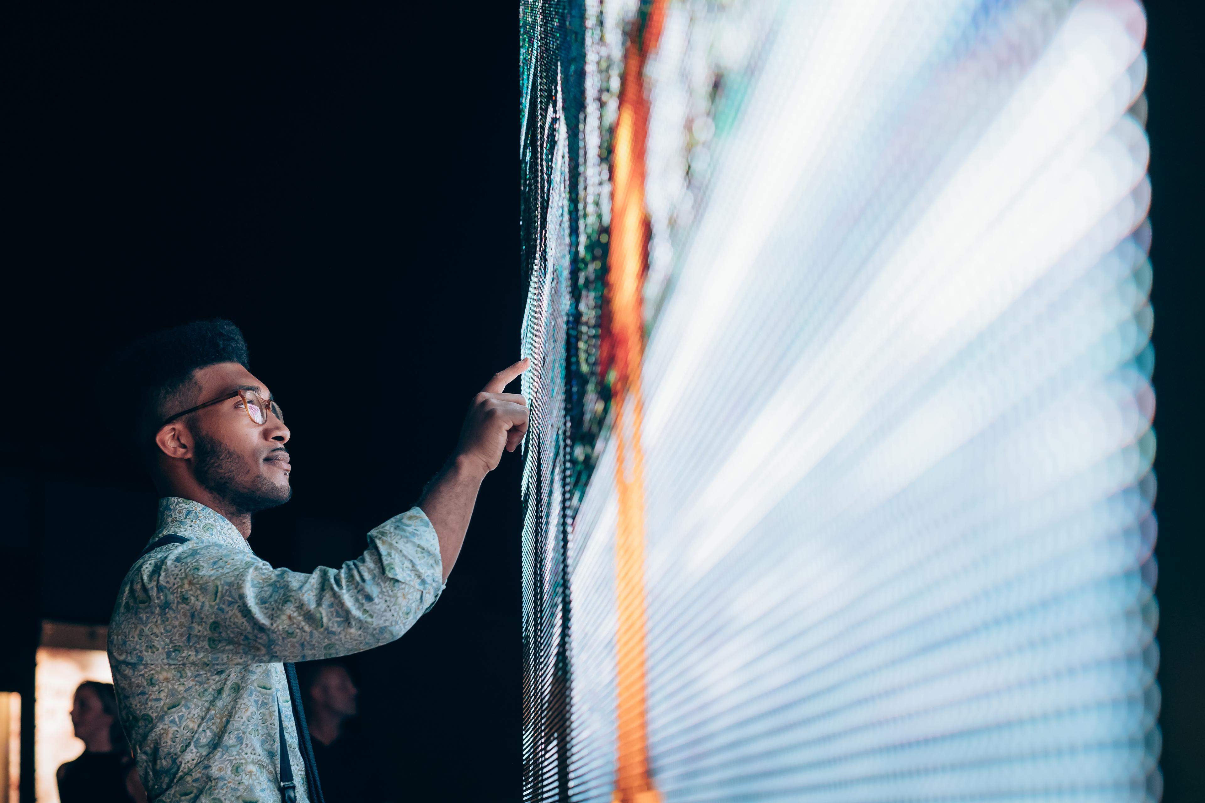 Person pointing at digital information board