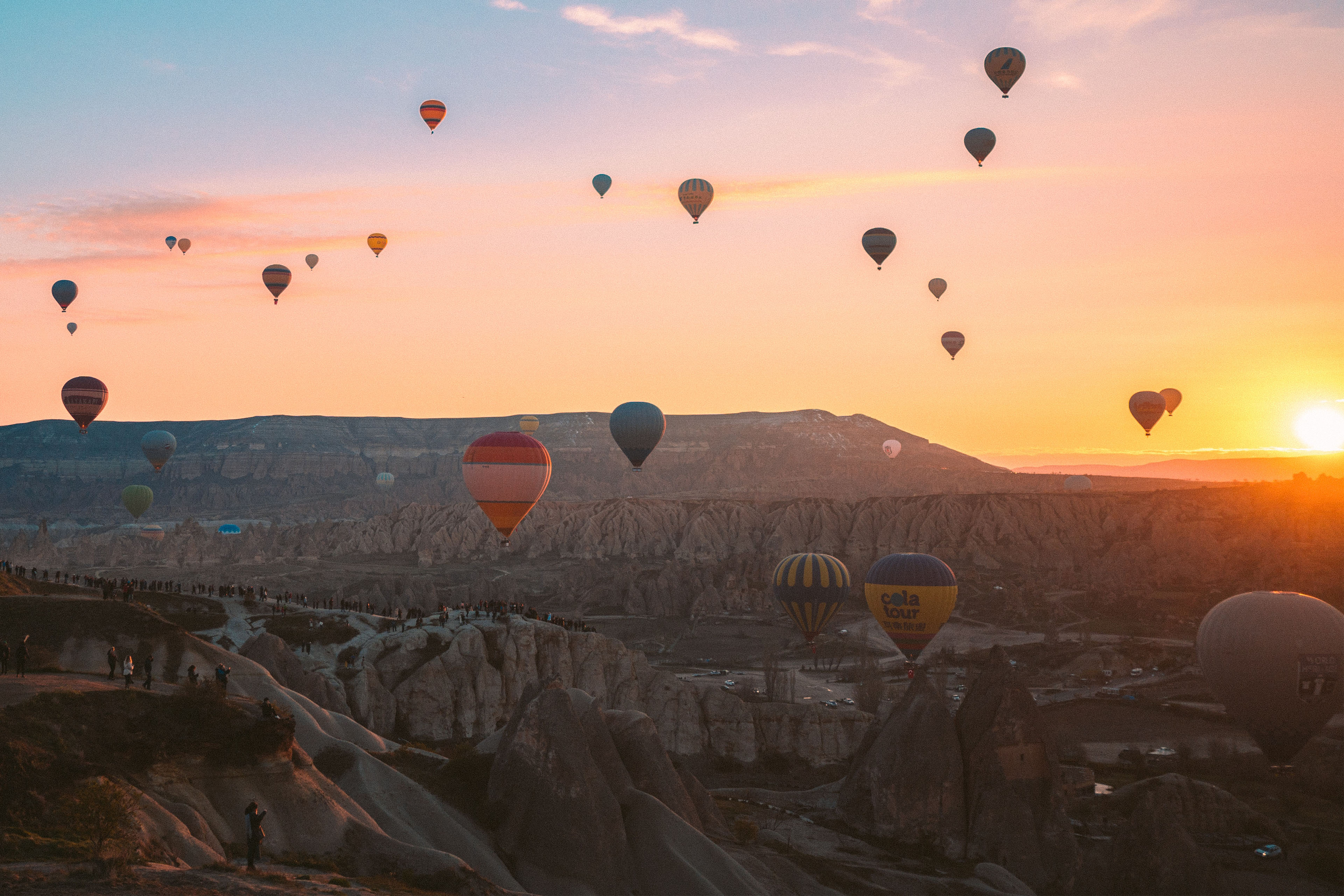 A picturesque sunrise scene with numerous hot air balloons in the sky