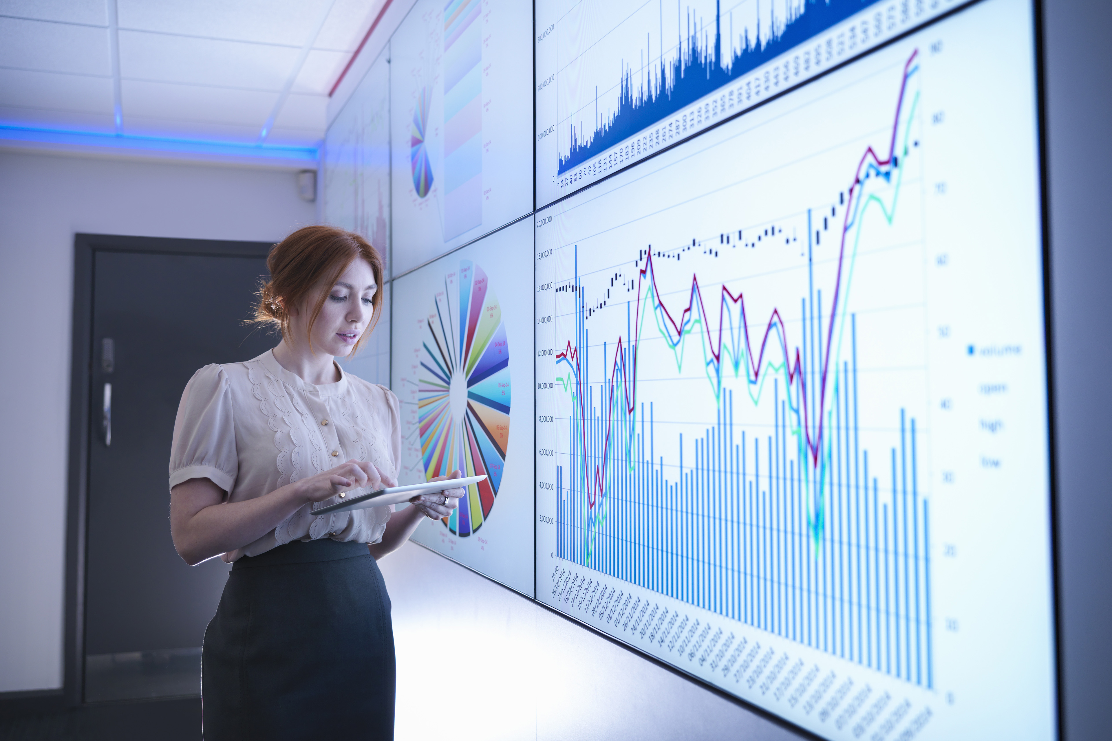 Businesswoman studying graphs on screen with digital tablet