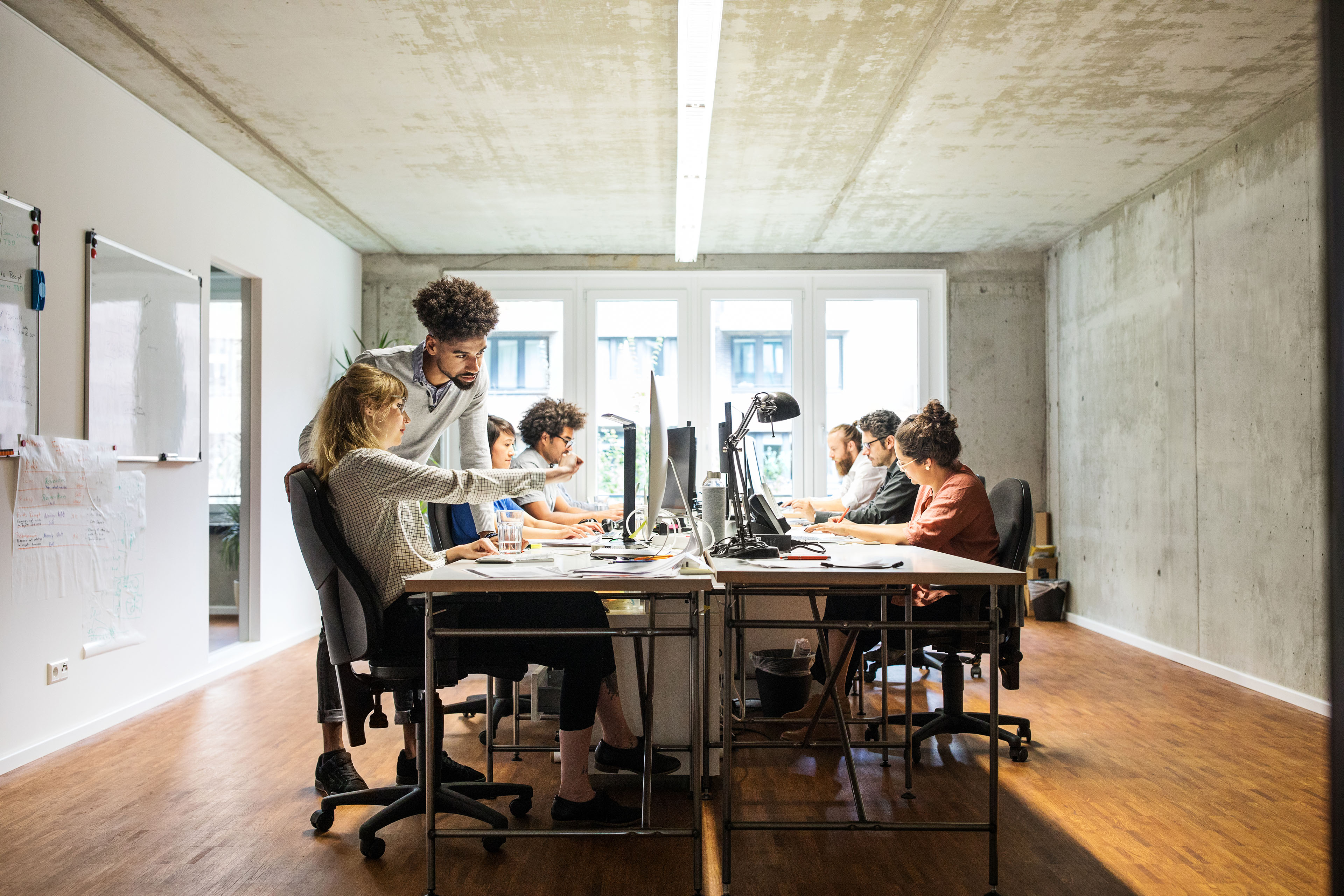 Business people discussing over computer in creative office