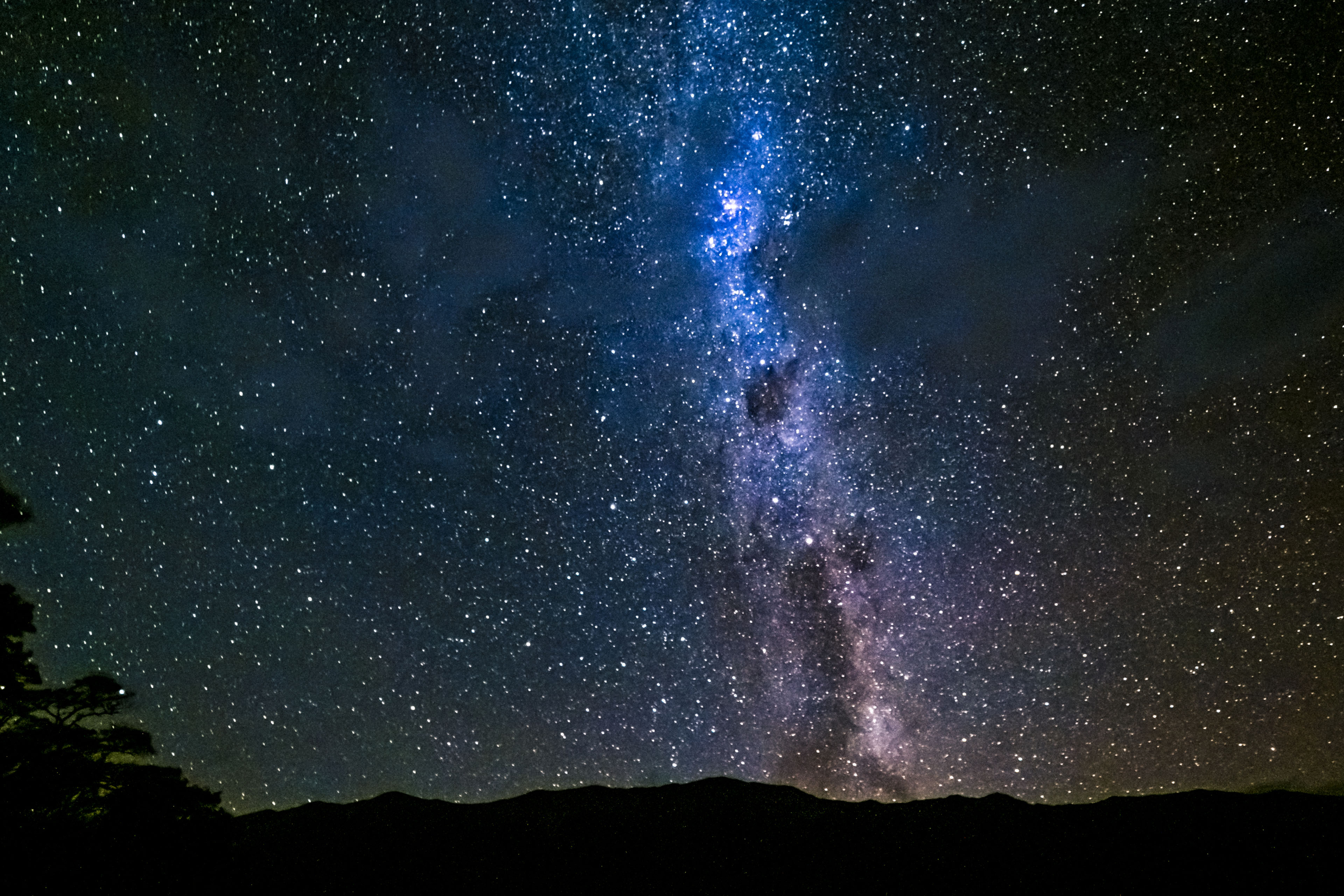 View of night sky and stars over hillside