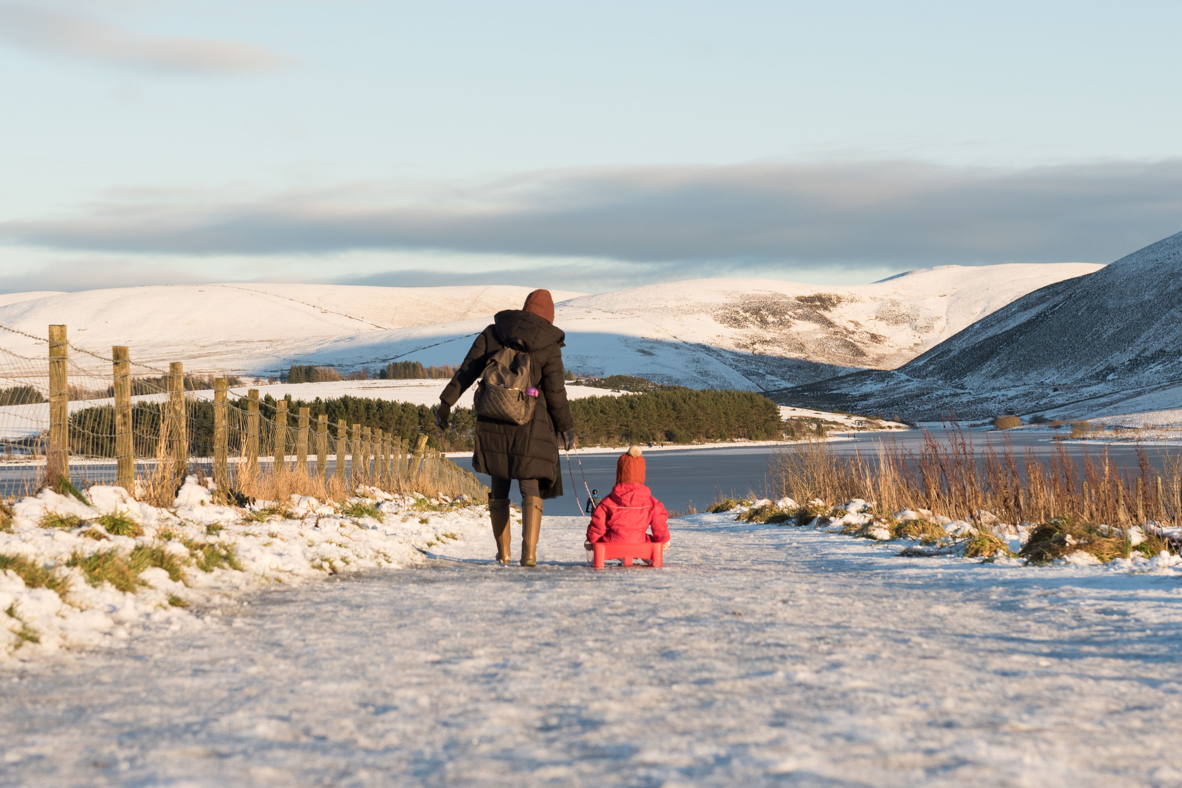 EY woman and kid walking in the snow