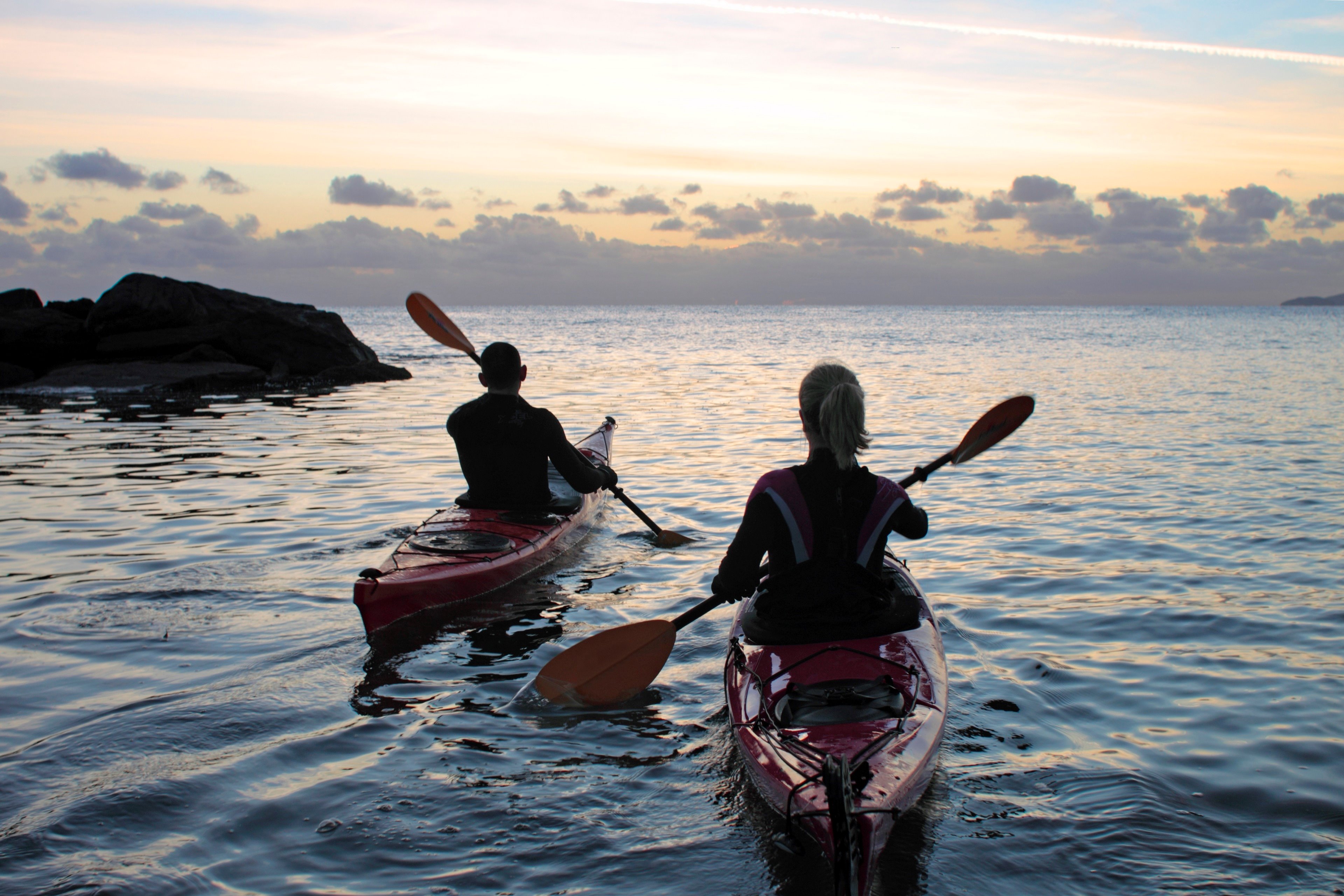 Photo of two canoeists rowing on water.