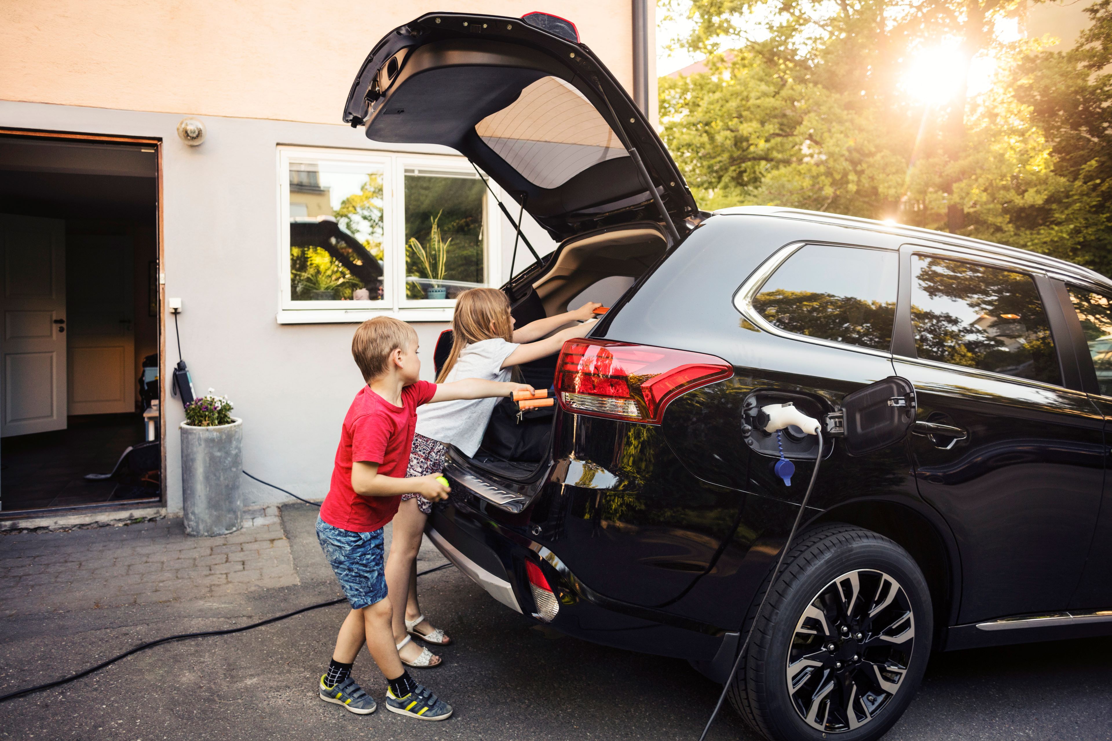 EY kids loading car trunk