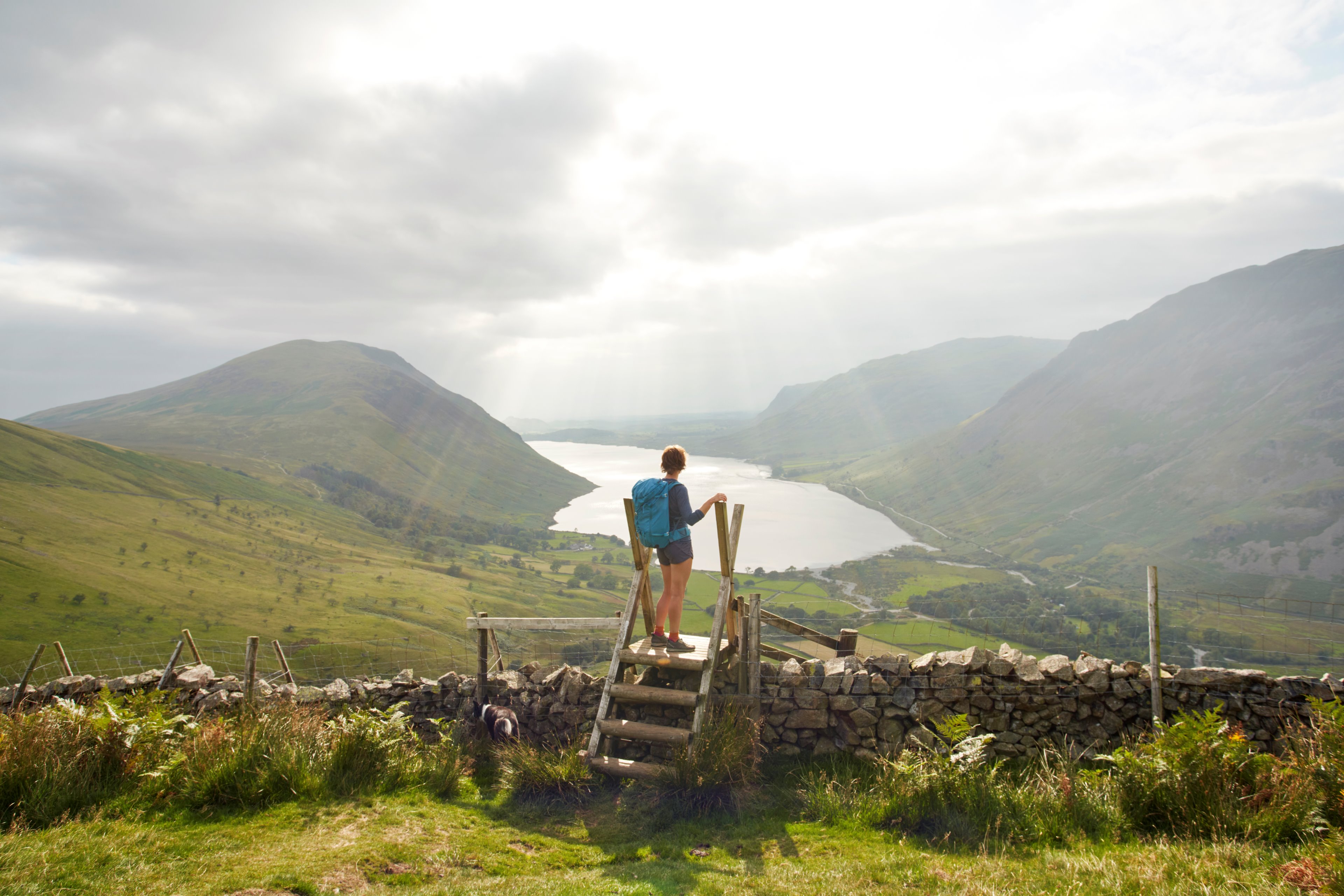 Photo of a hiker looking over a lake in the mountains