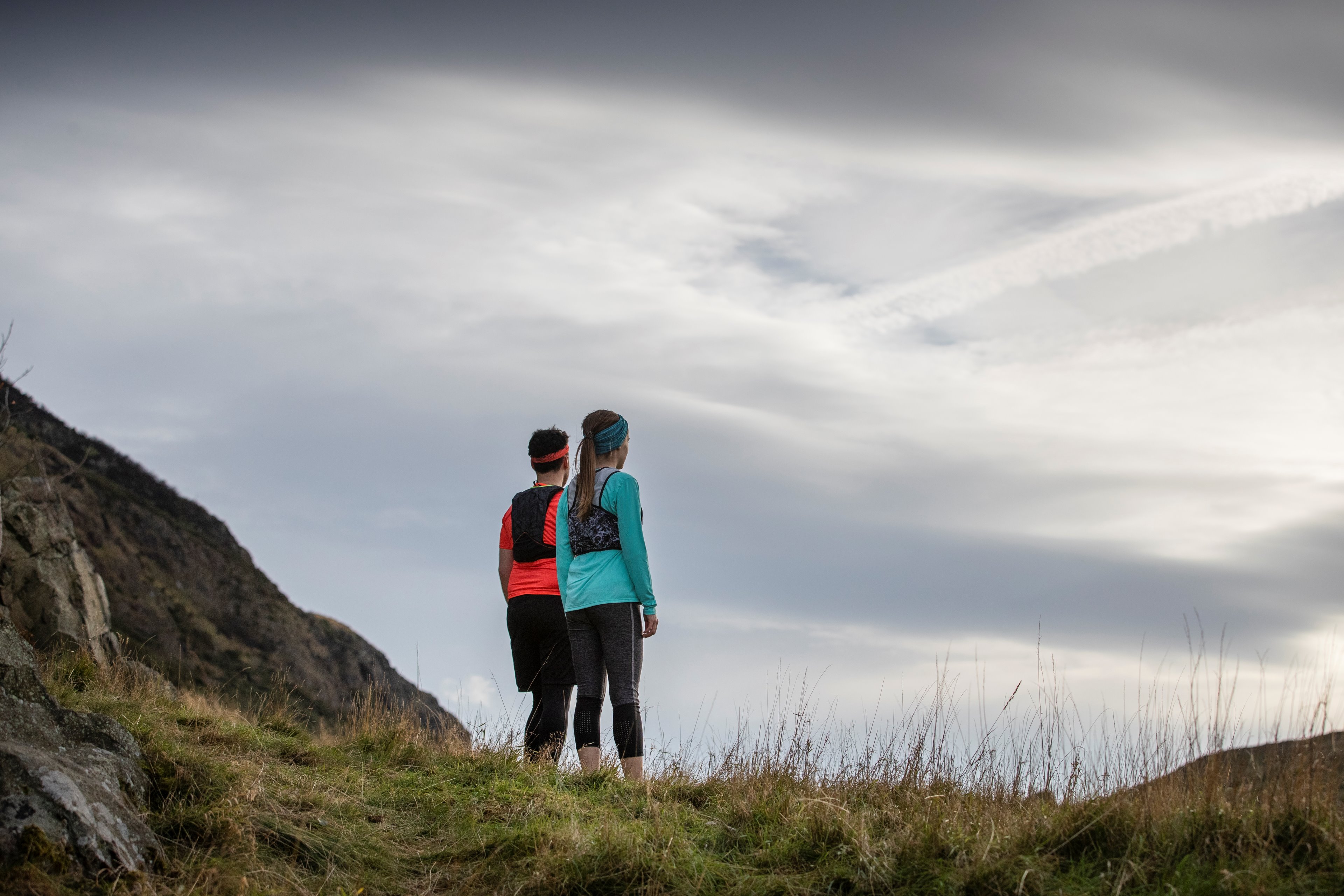 Photograph of two runners standing on a mountain path.