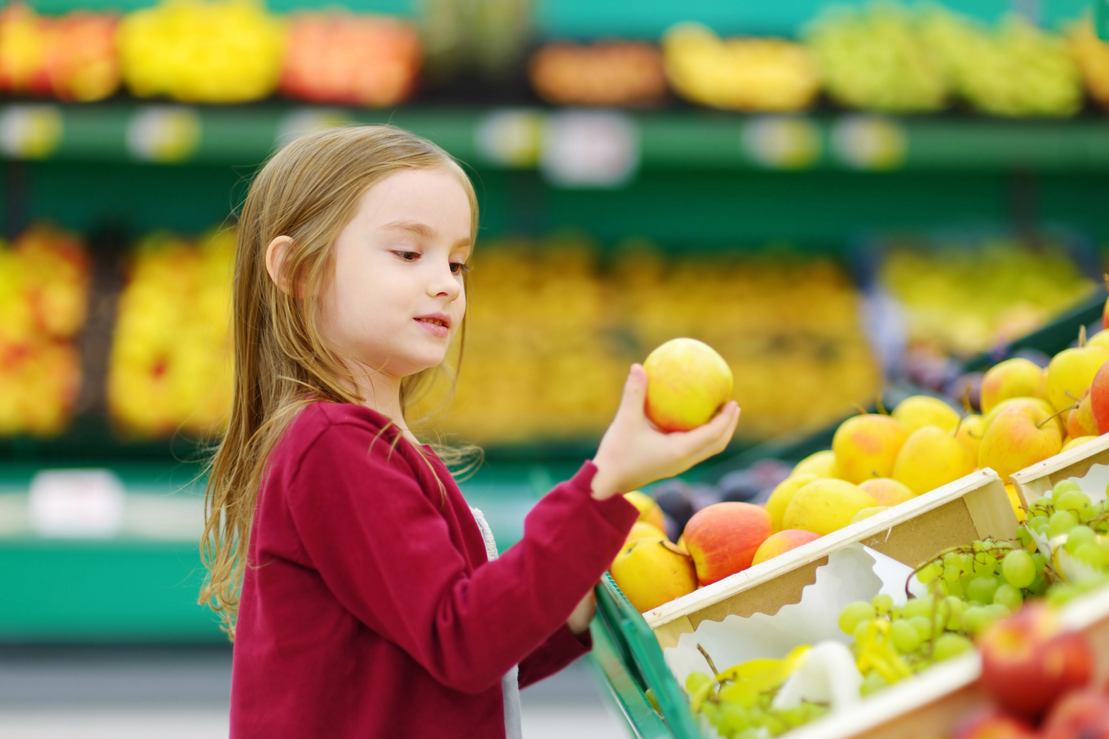 Little girl choosing an apple