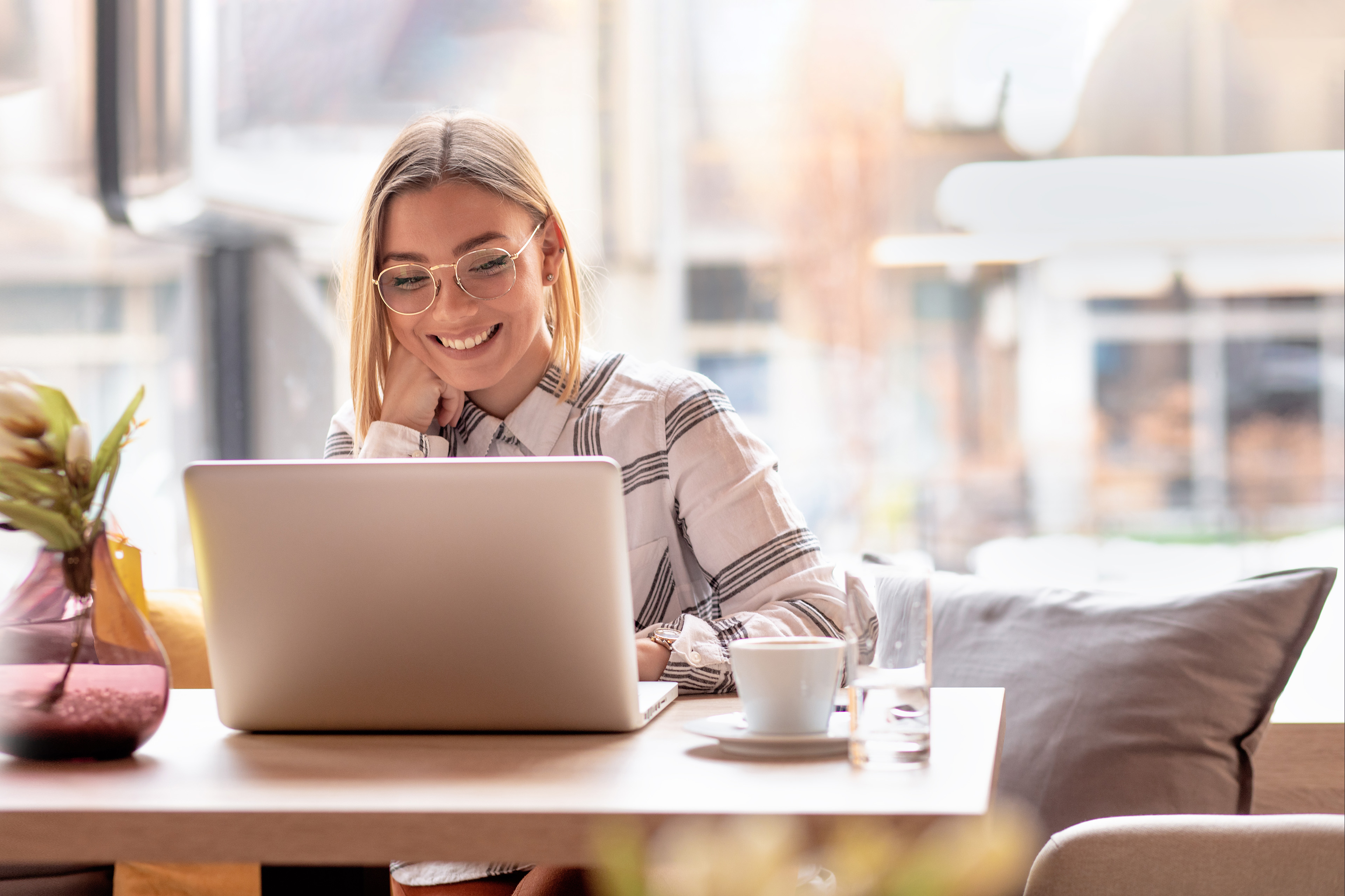 Portrait of young woman using laptop at cafe