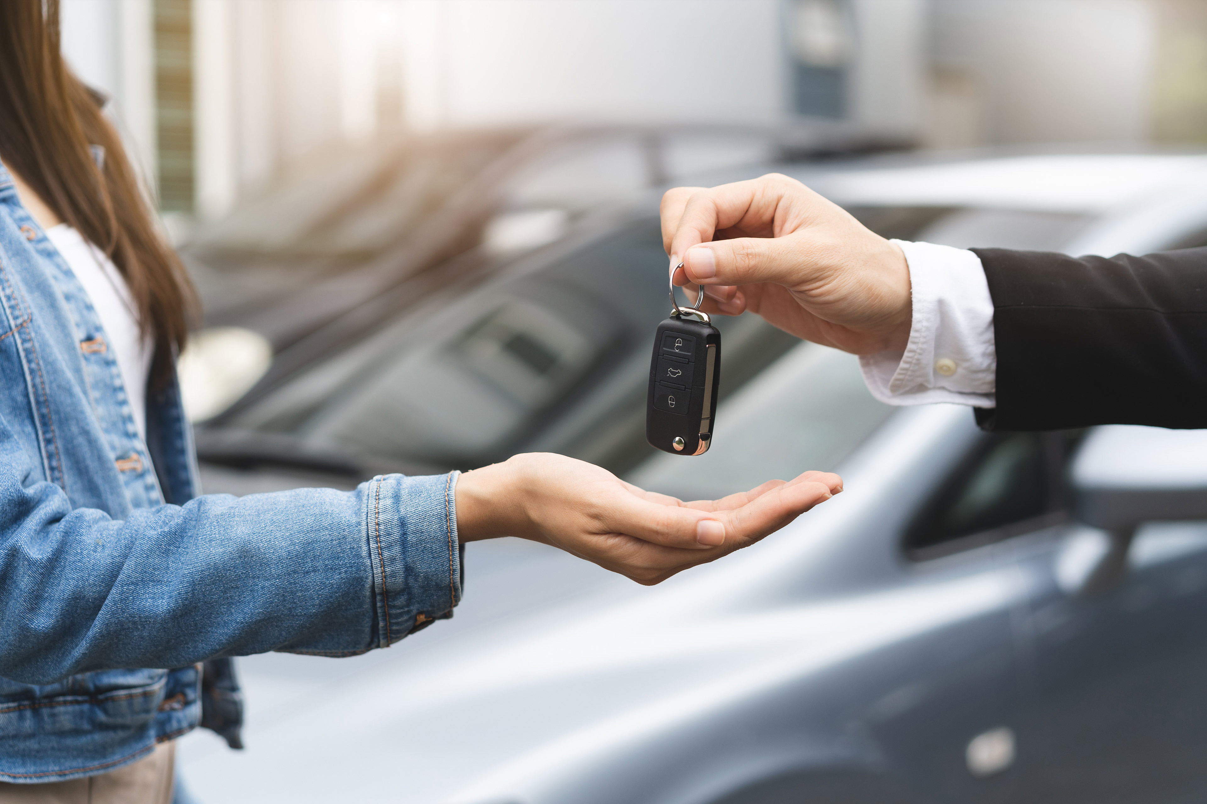 EY auto salesman giving customer the keys