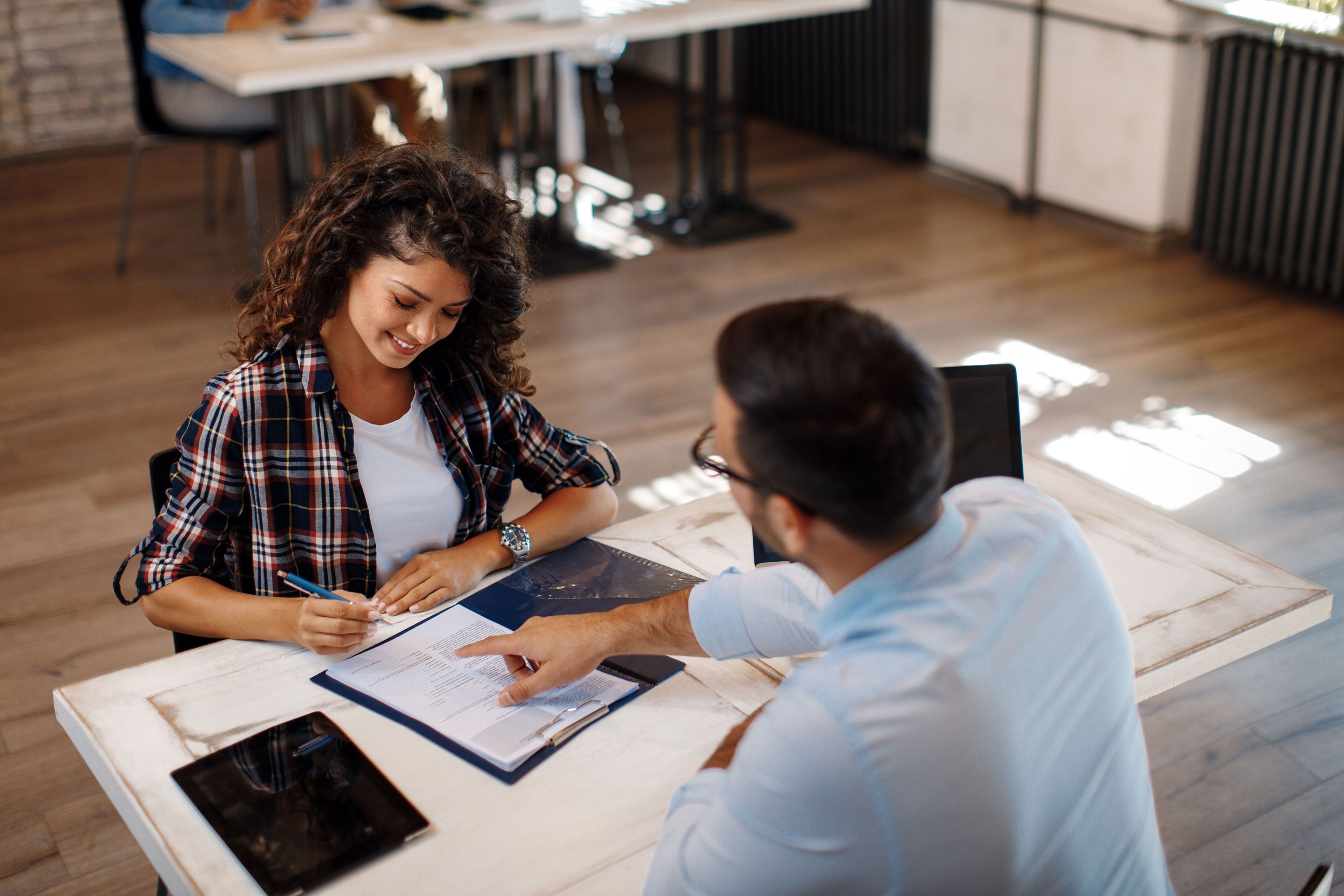 Young woman signing contract with manager