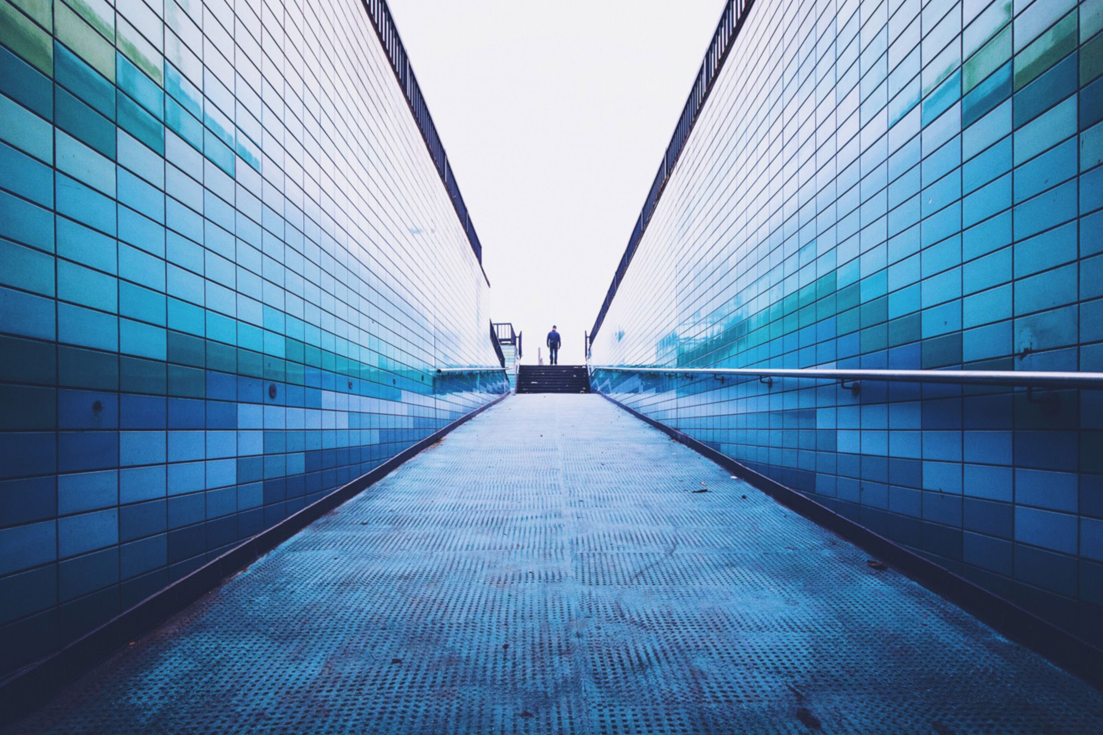 EY - Man-walking-on-footpath-amidst-surrounding-wall