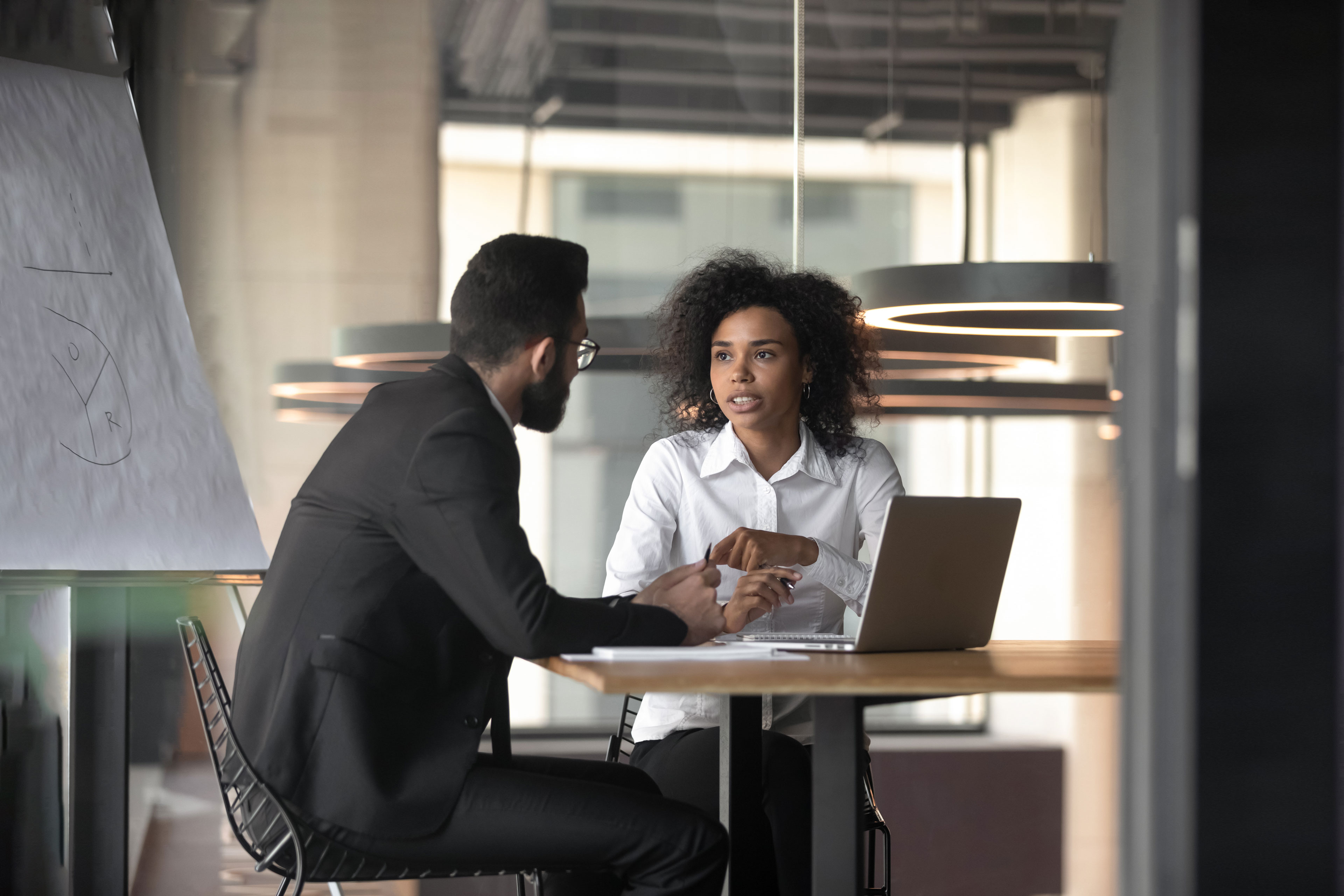 African American businesswoman consulting client in boardroom