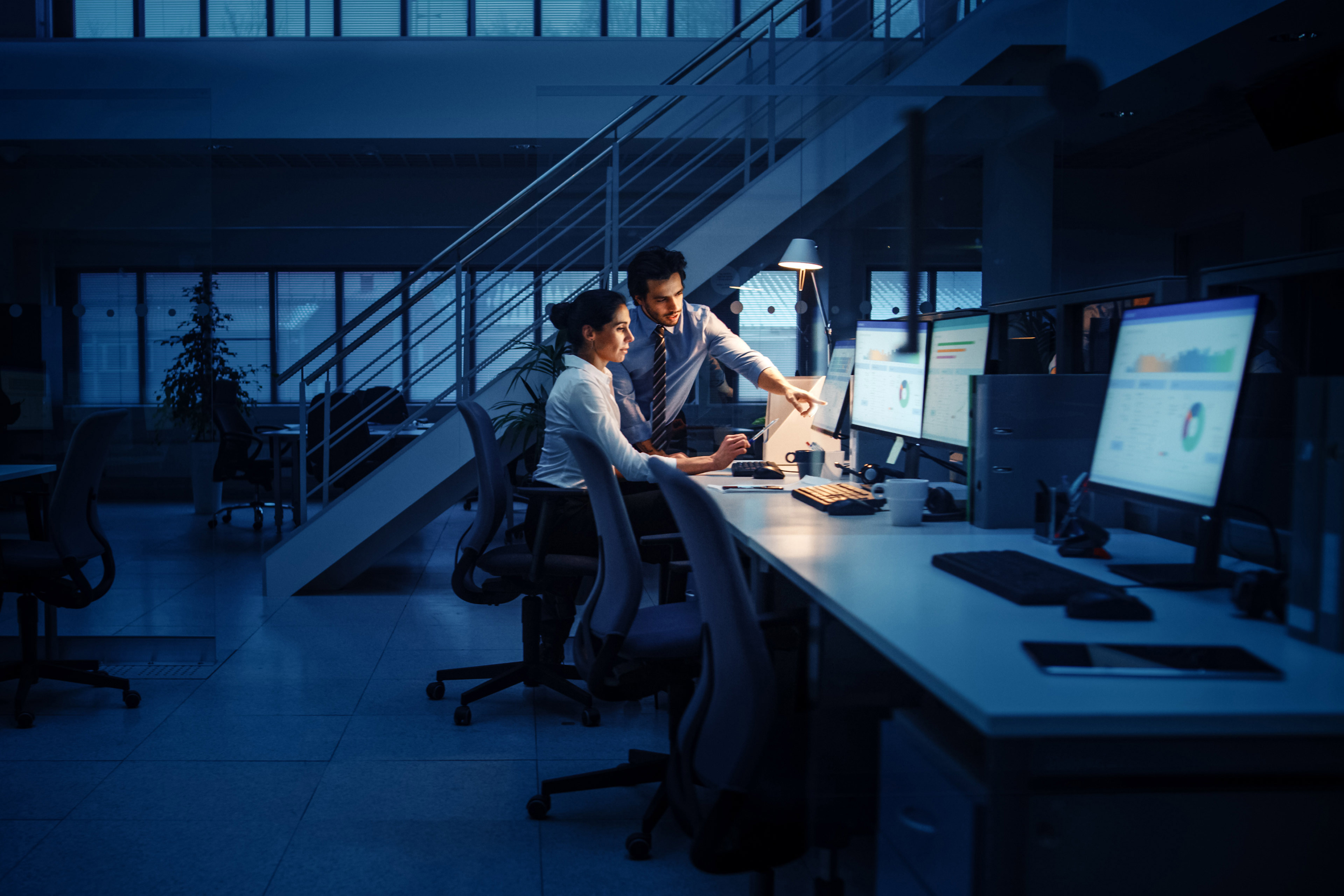 Businessman and woman work on computer having discussion