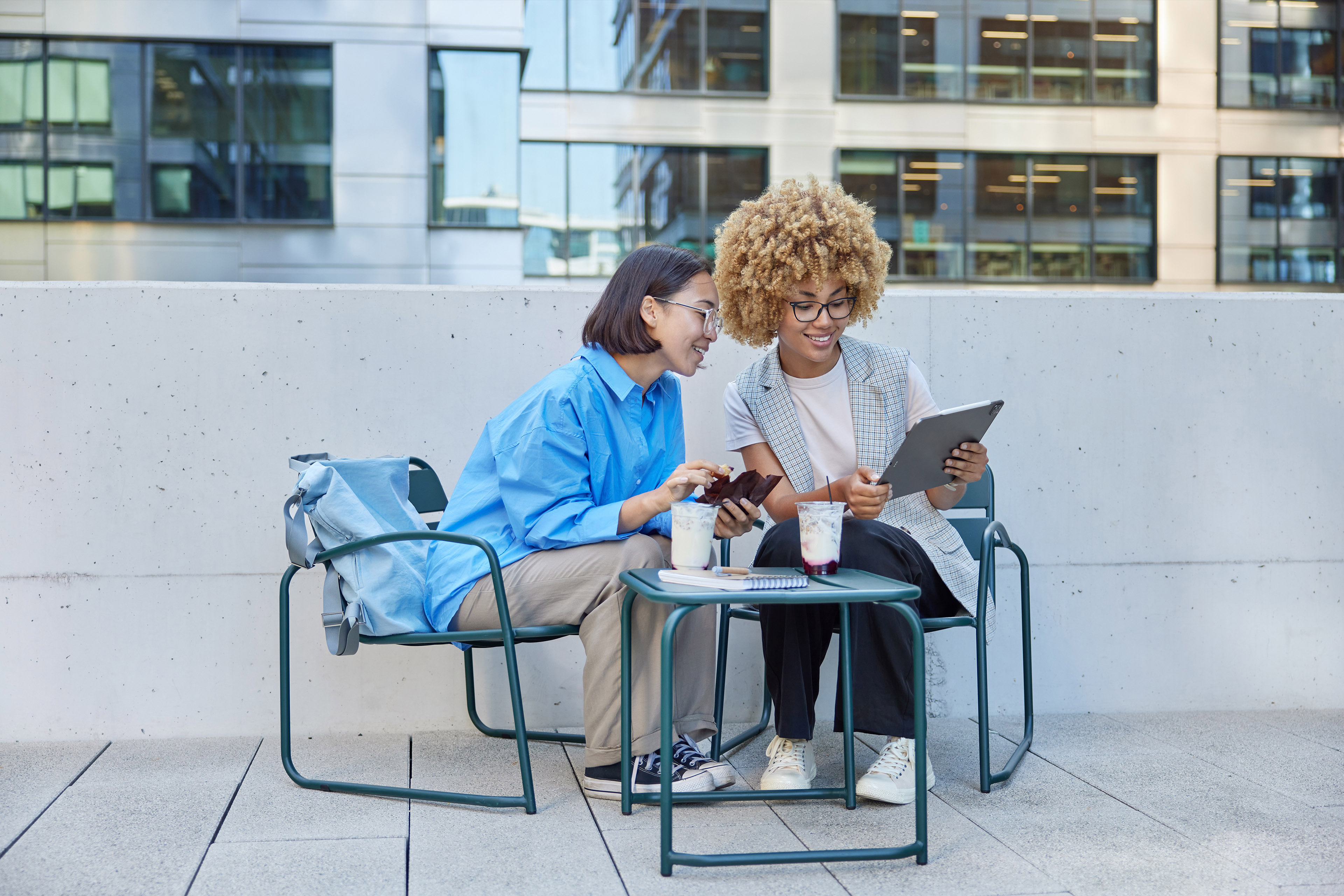 Diverse female students watching video via digital tablet