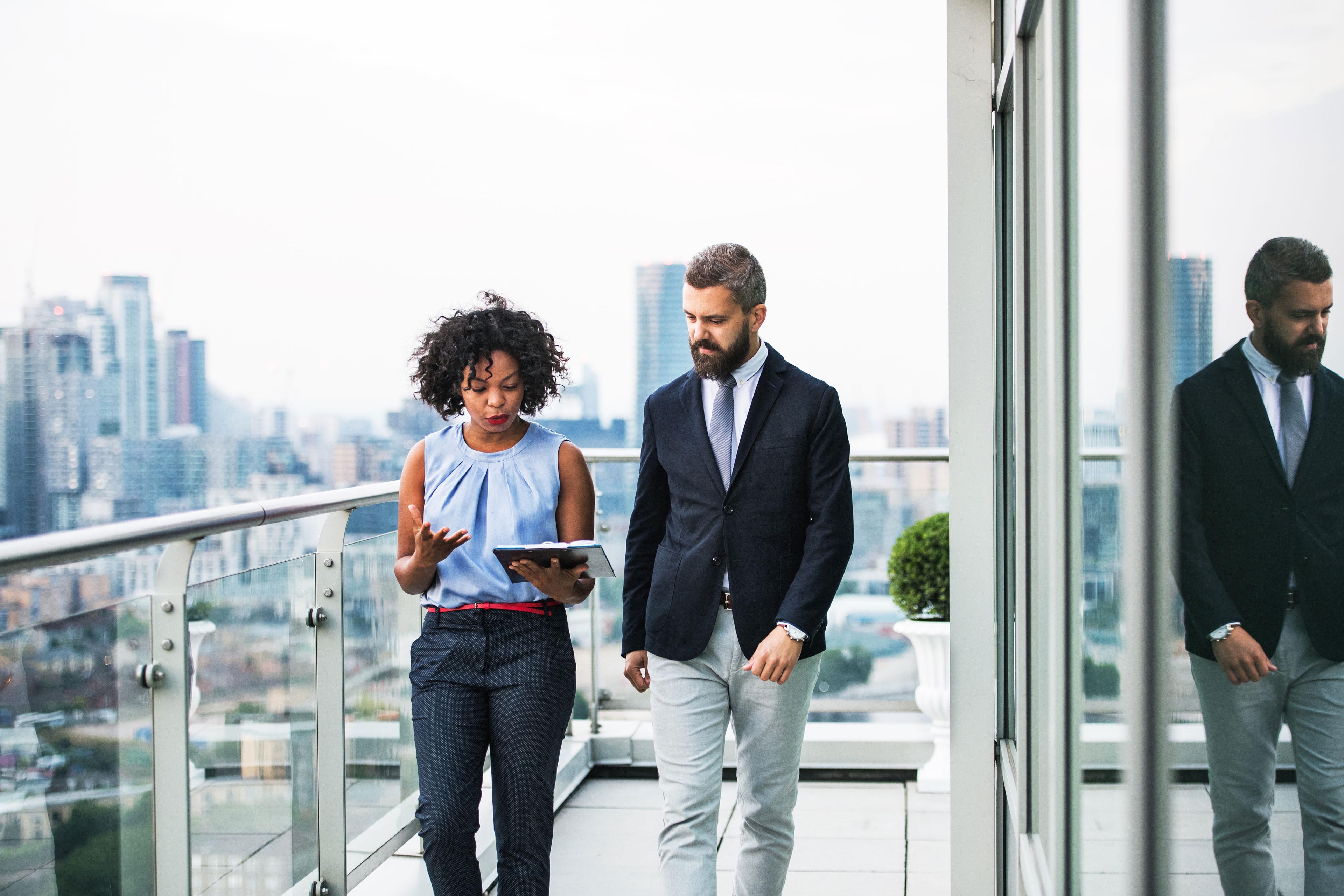 Two business people walking on balcony