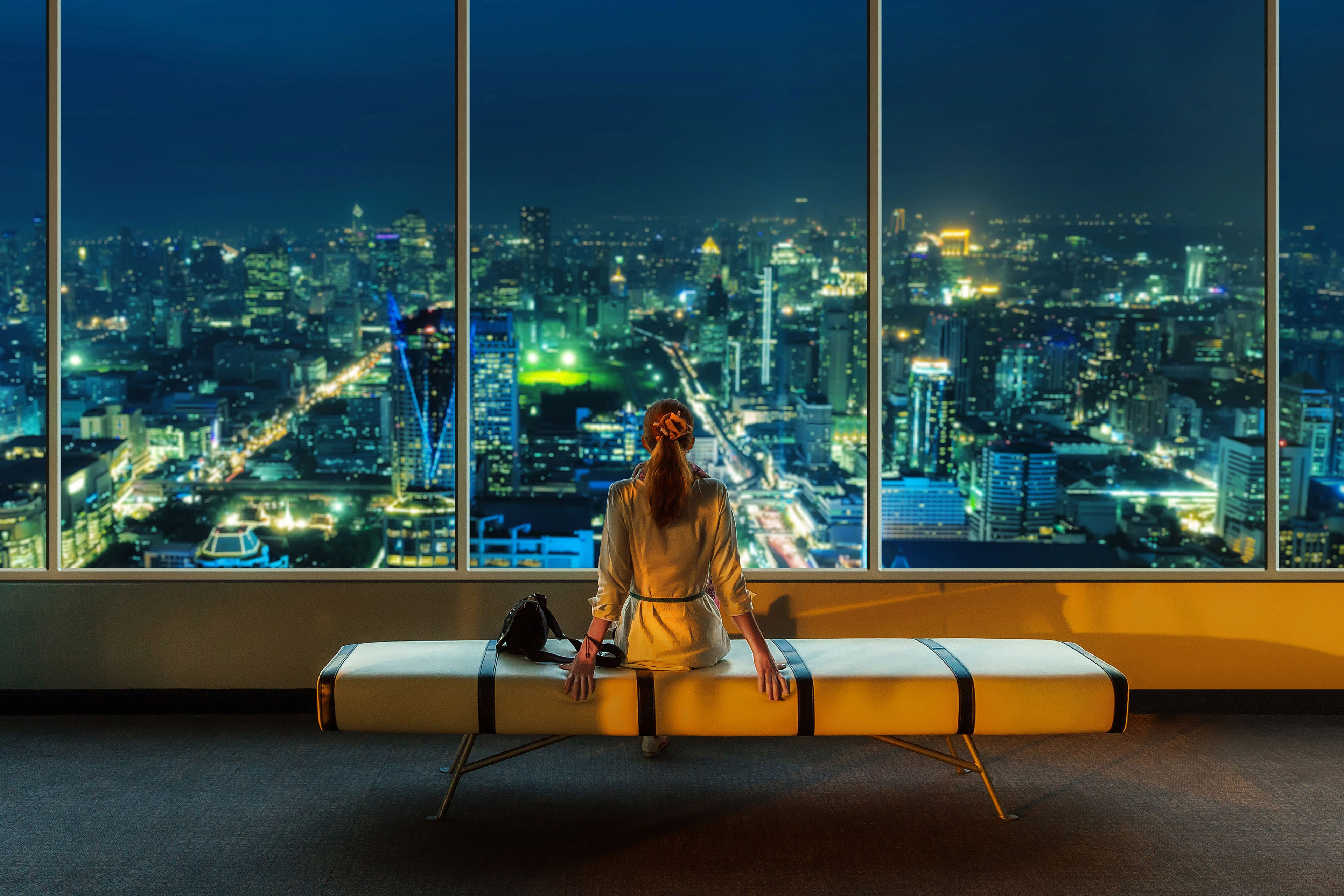 Woman viewing cityscape from window