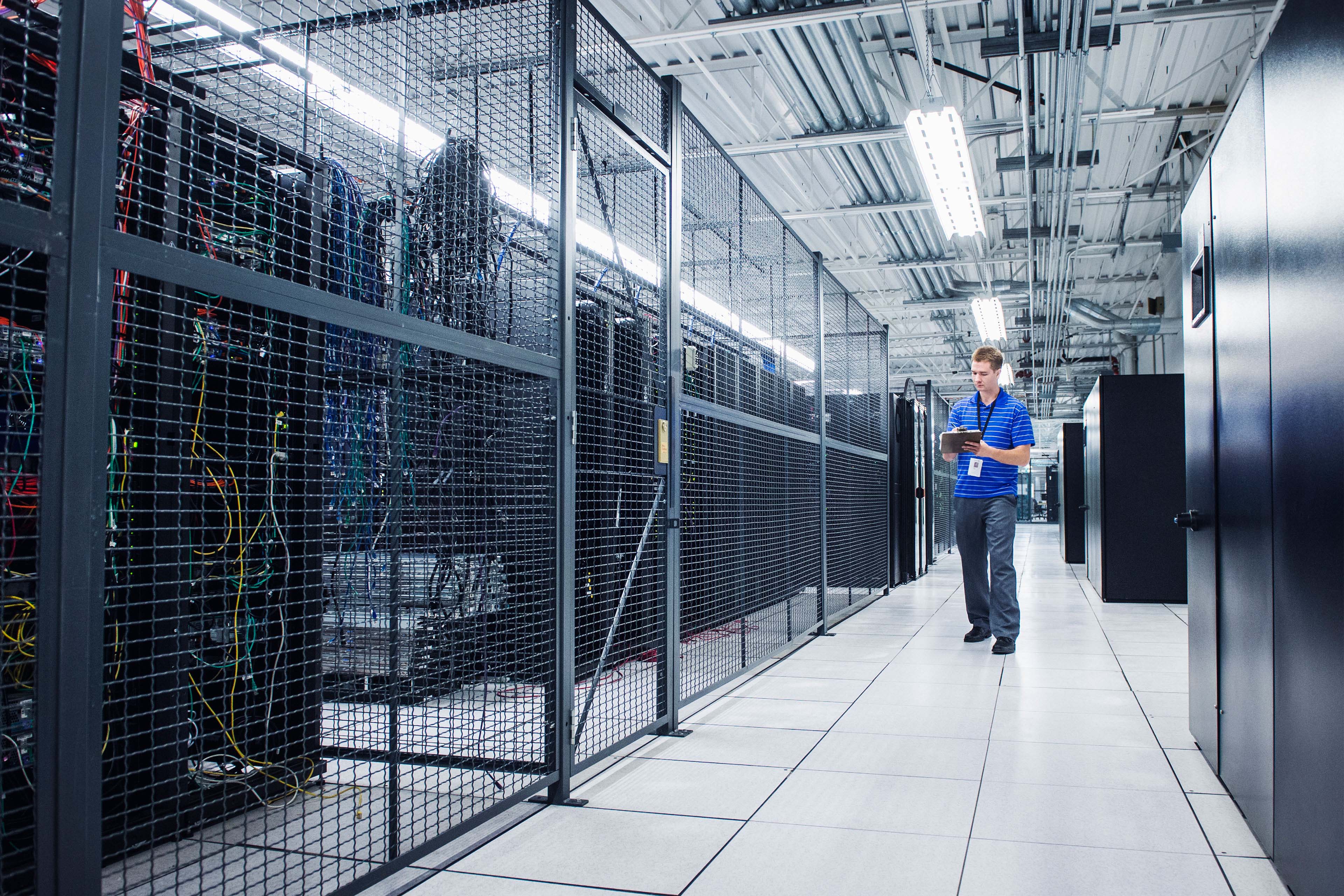 ey caucasian technician using digital tablet in server room