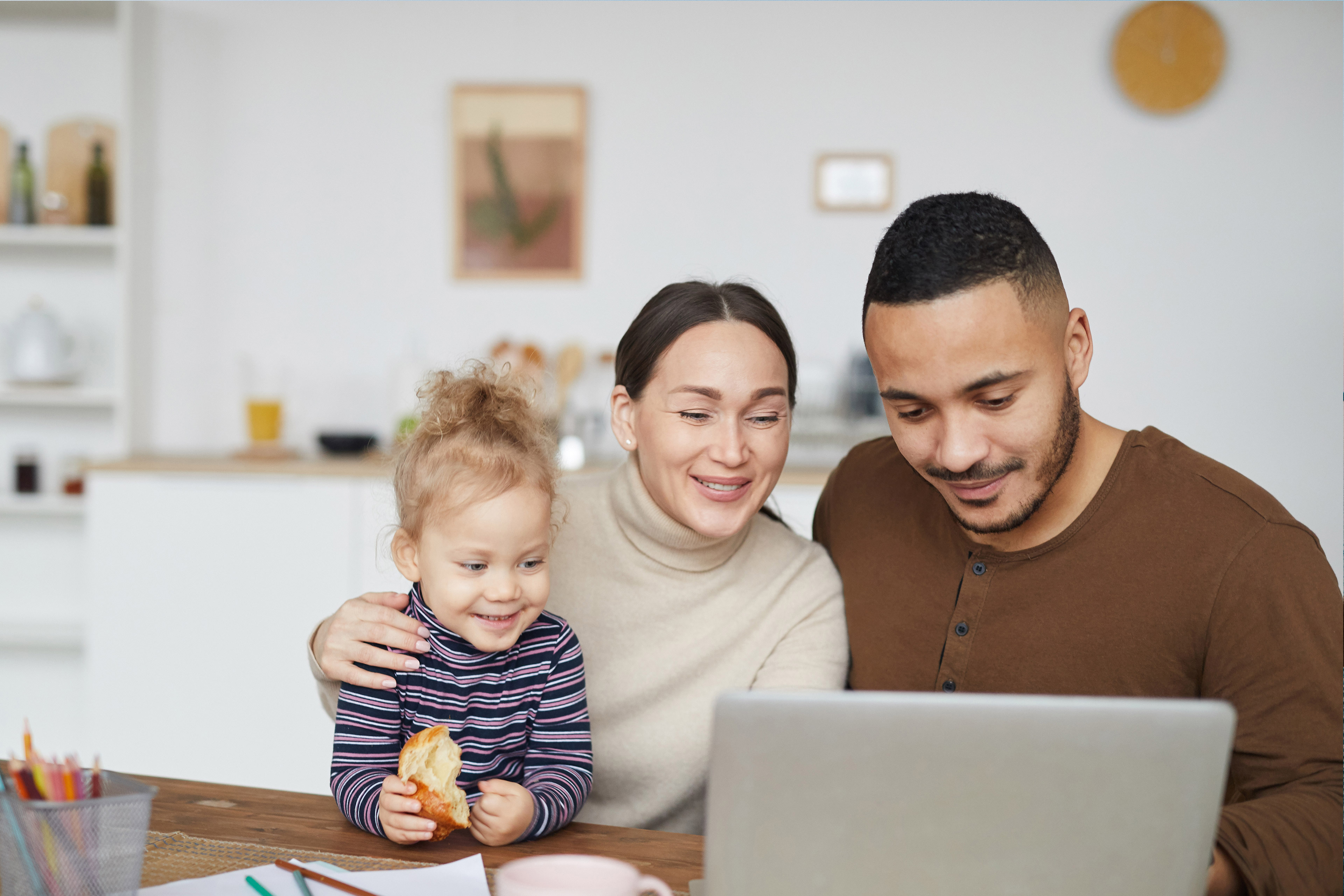 Happy Mixed-Race Family Using Laptop at Home