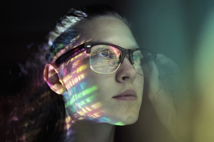 Girl wearing glasses lighted with colorful code