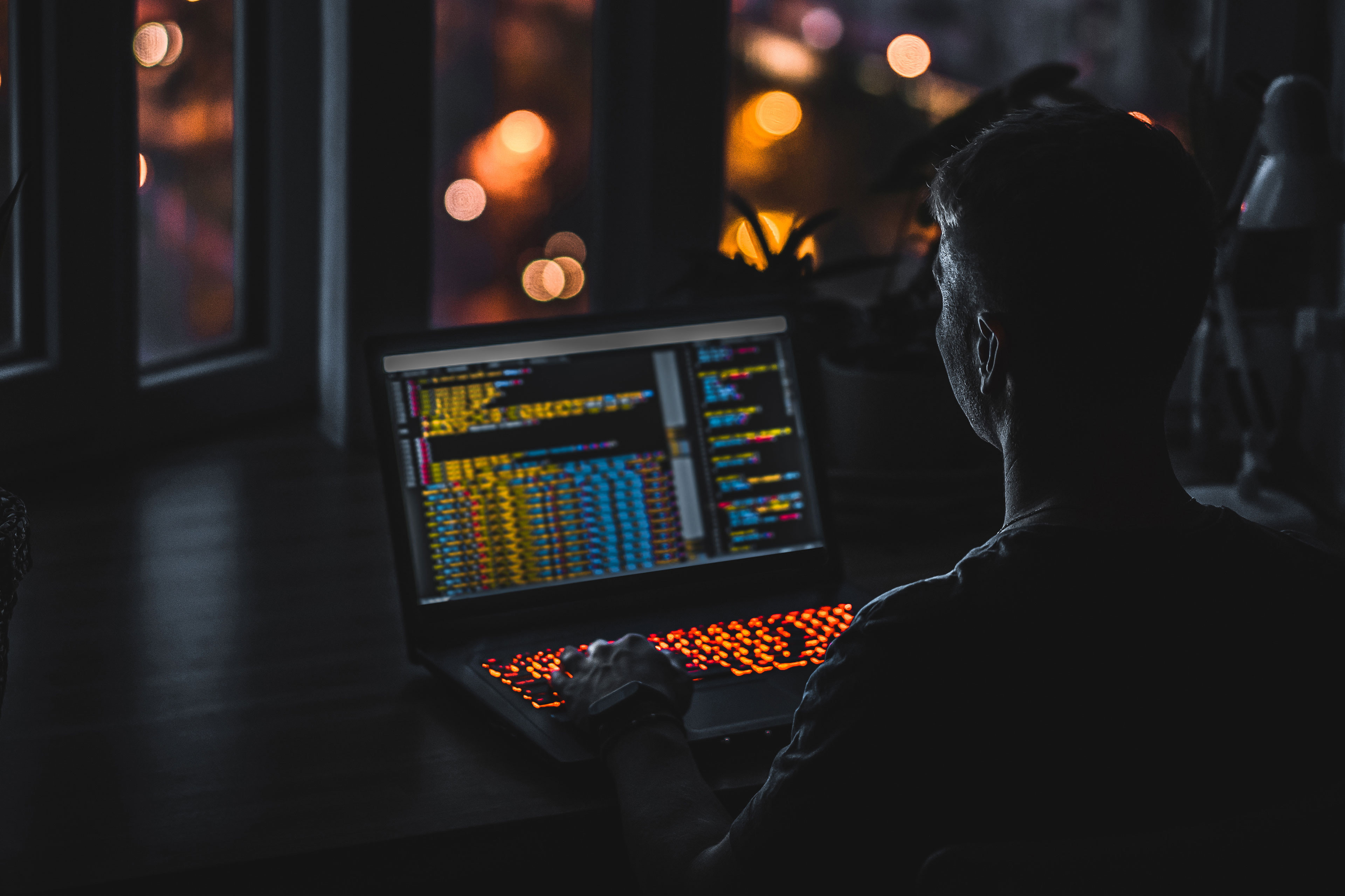 Young man programmer coding on a laptop