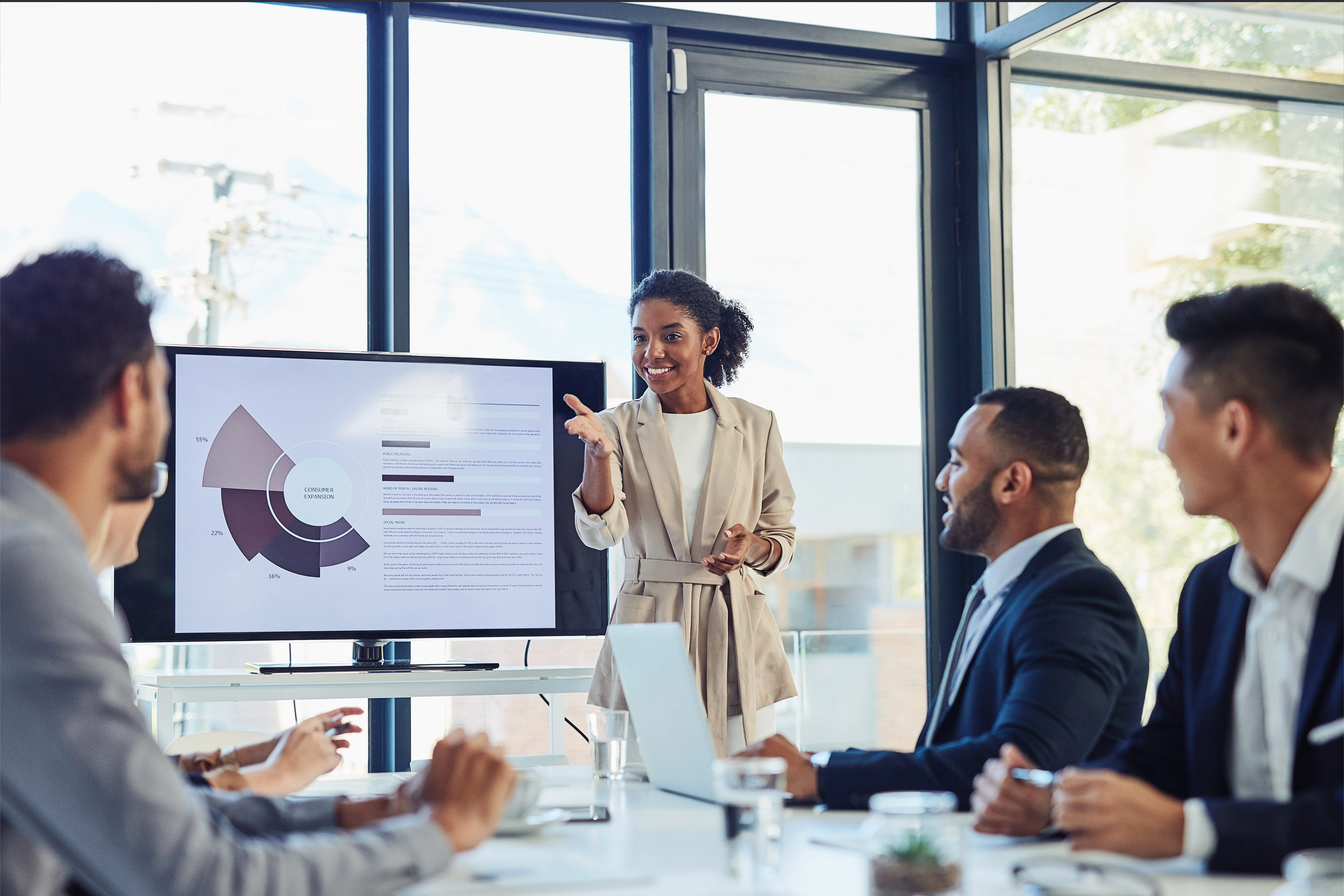 Businesswoman and presentation on screen of tv in modern boardroom with colleagues