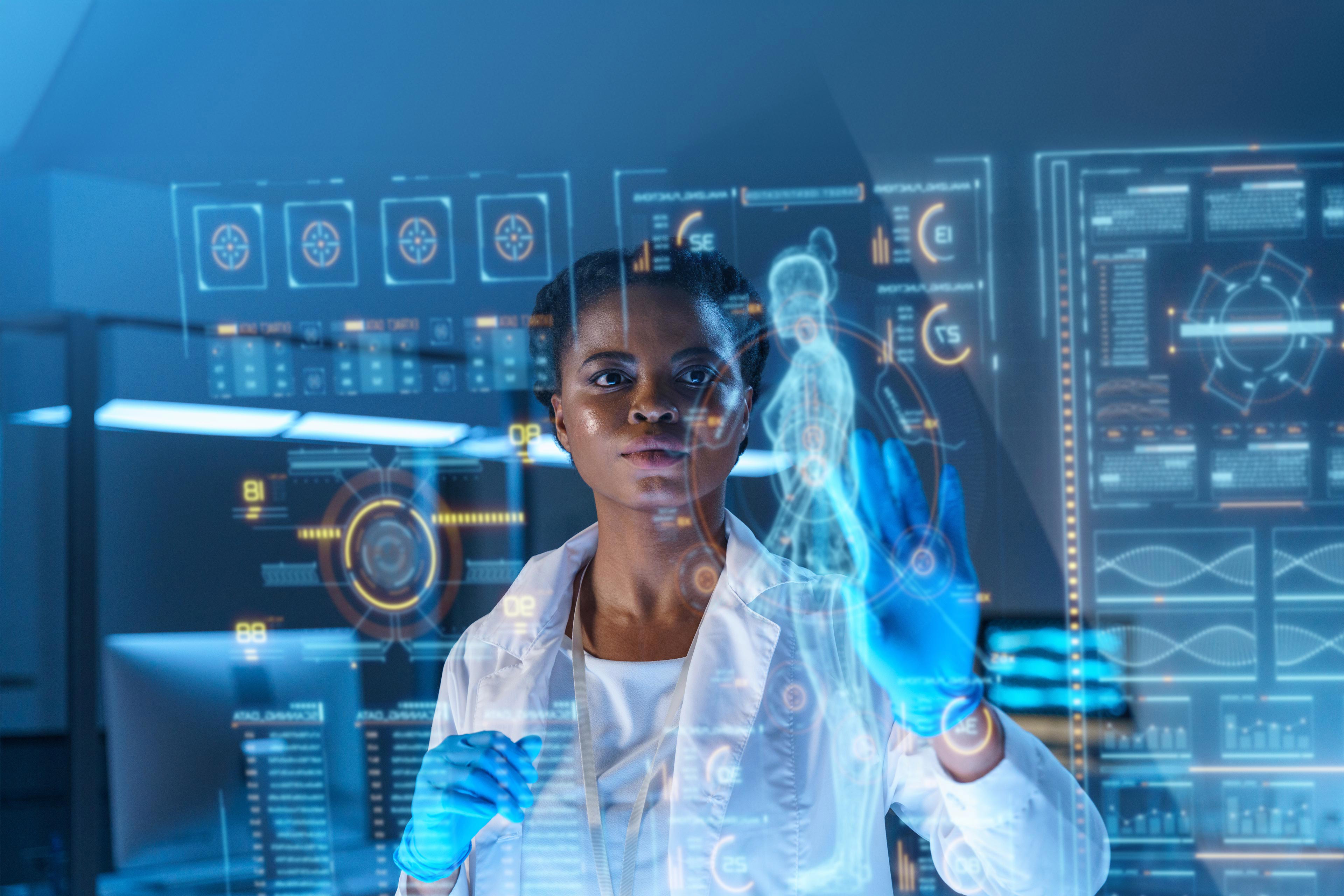 A young African - American doctor works on HUD or graphic display in front of her